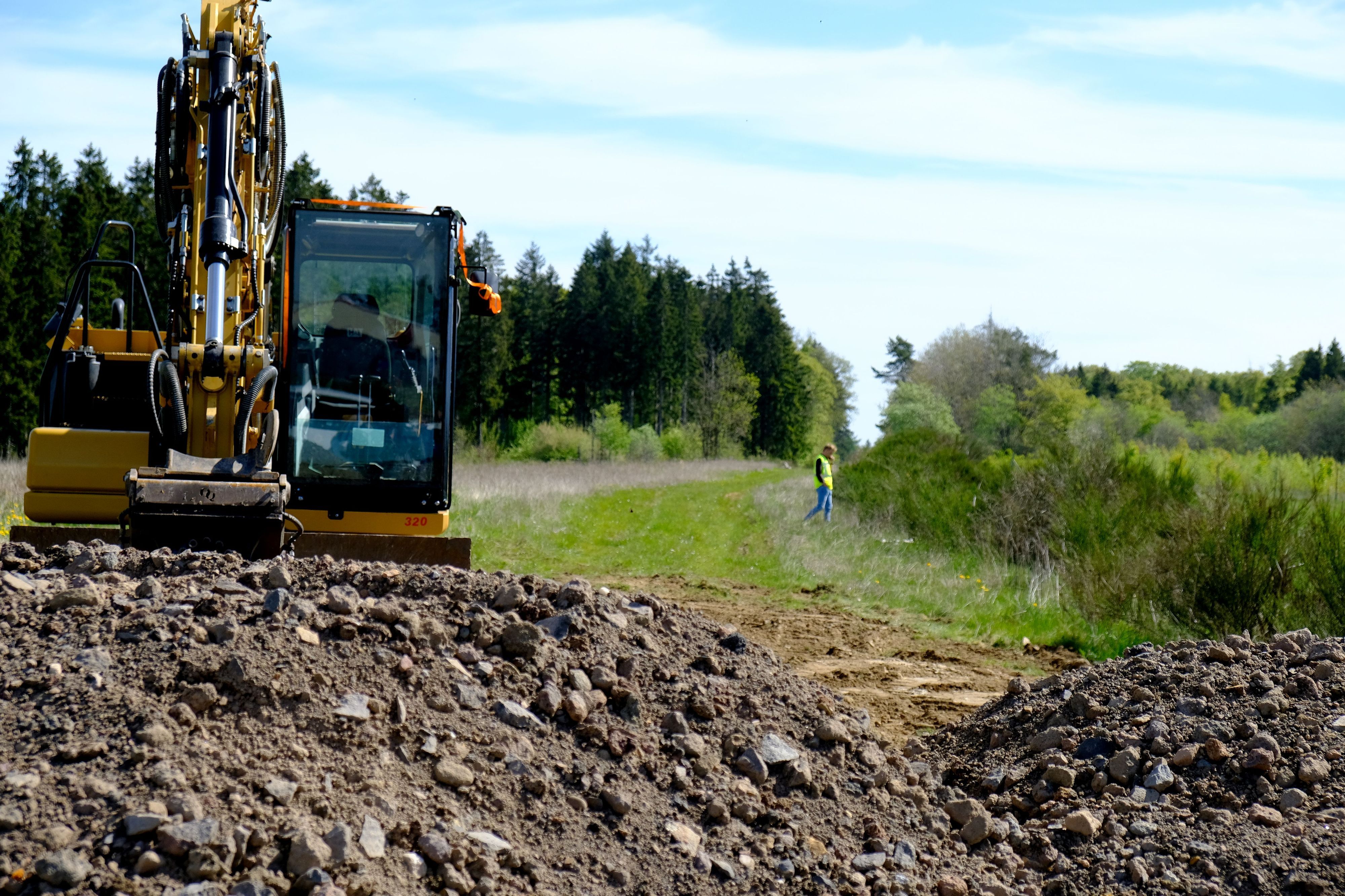 Unweit der Anschlussstelle Kelberg steht ein Bagger an einem Erdhaufen.