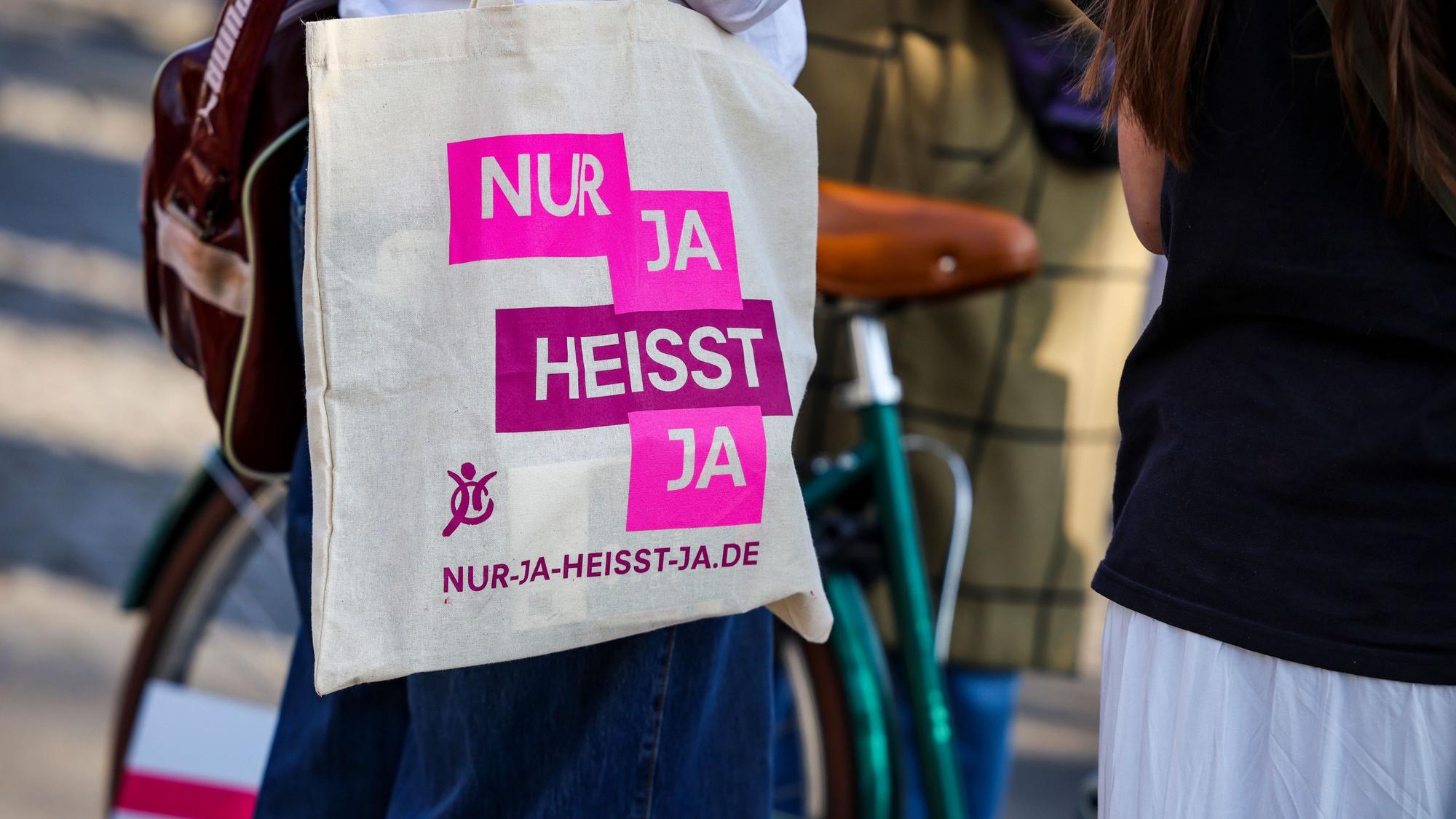Bei einer Demo in Köln zum Internationalen Frauentag trägt eine Teilnehmerin eine Stofftasche mit der Aufschrift „Nur Ja heißt Ja“. (Archivbild)