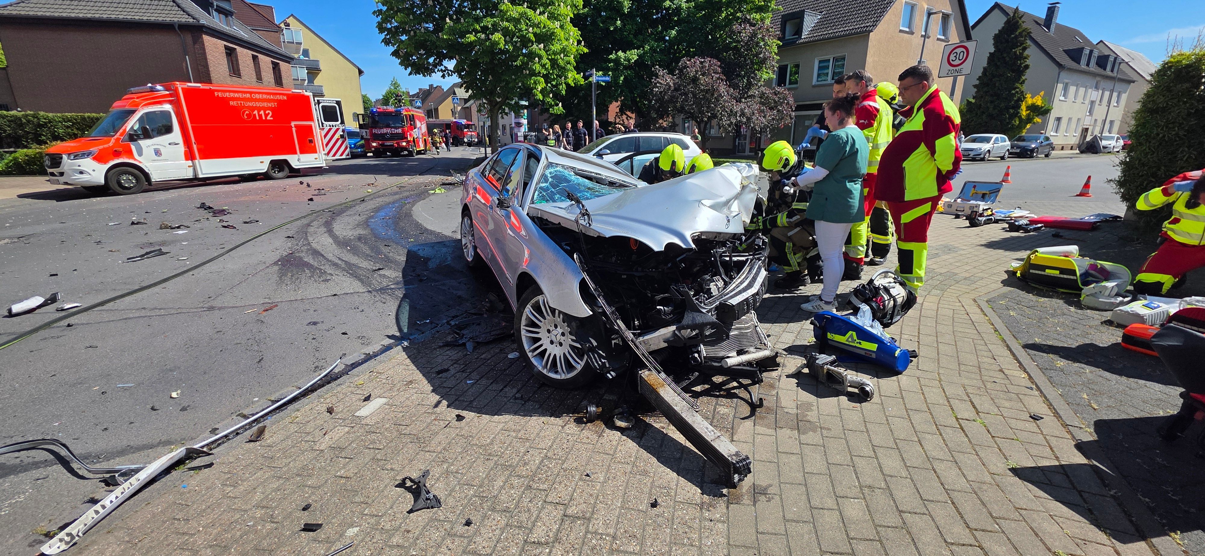 Die Feuerwehr am Unfallort vor dem völlig zerstörten Mercedes.