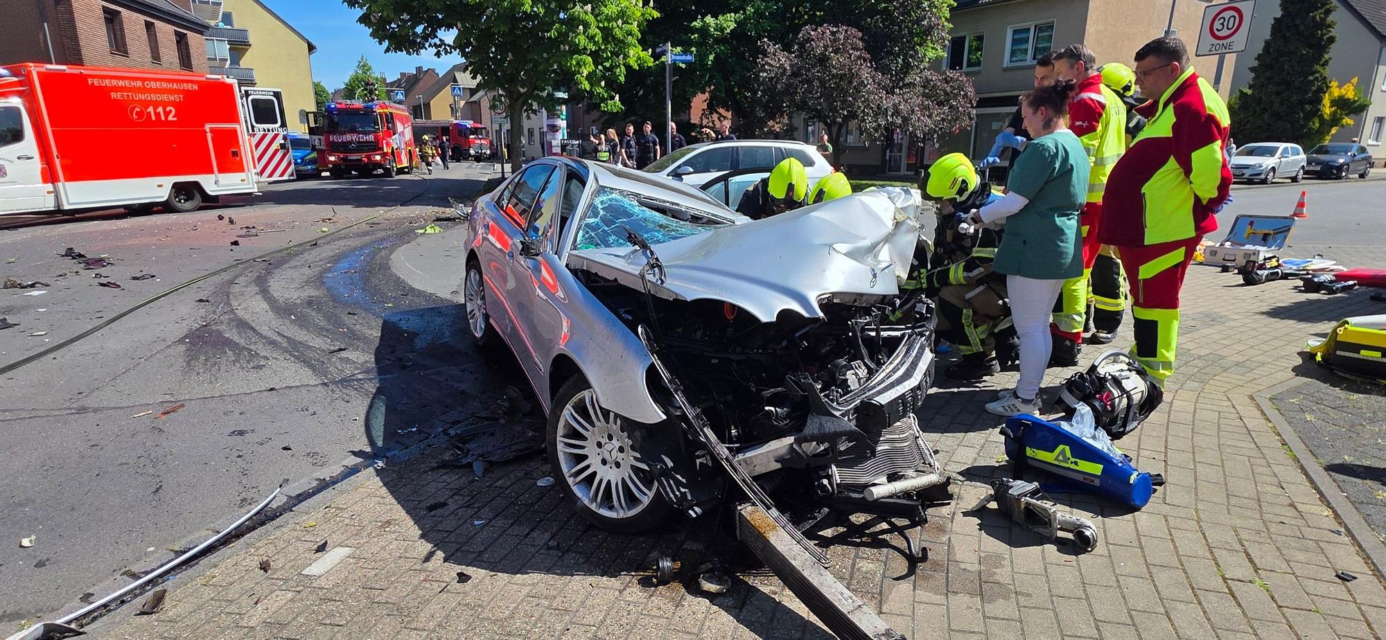 Die Feuerwehr am Unfallort vor dem völlig zerstörten Mercedes.