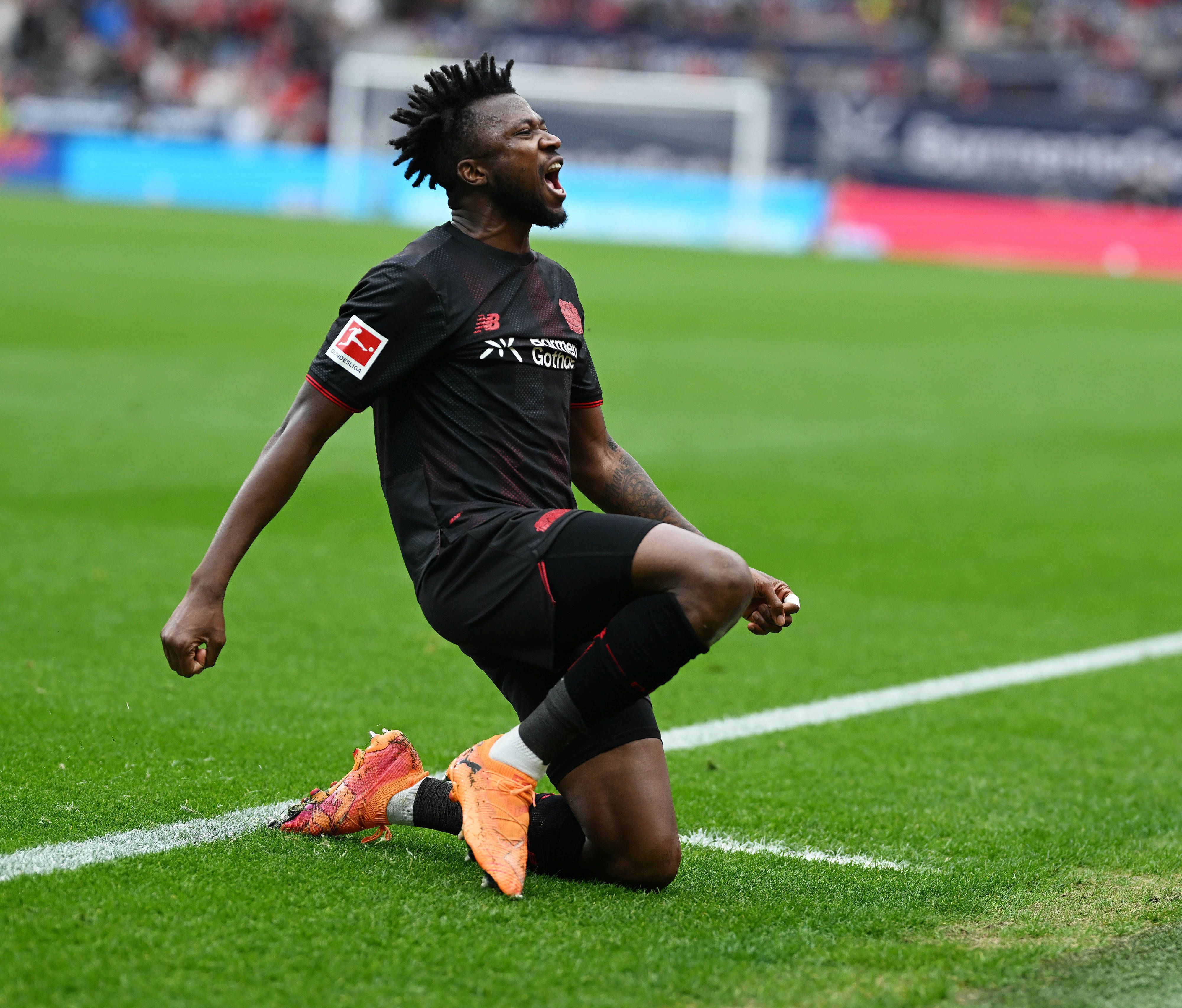 Edmond Tapsoba jubelt im Trikot von Bayer Leverkusen.