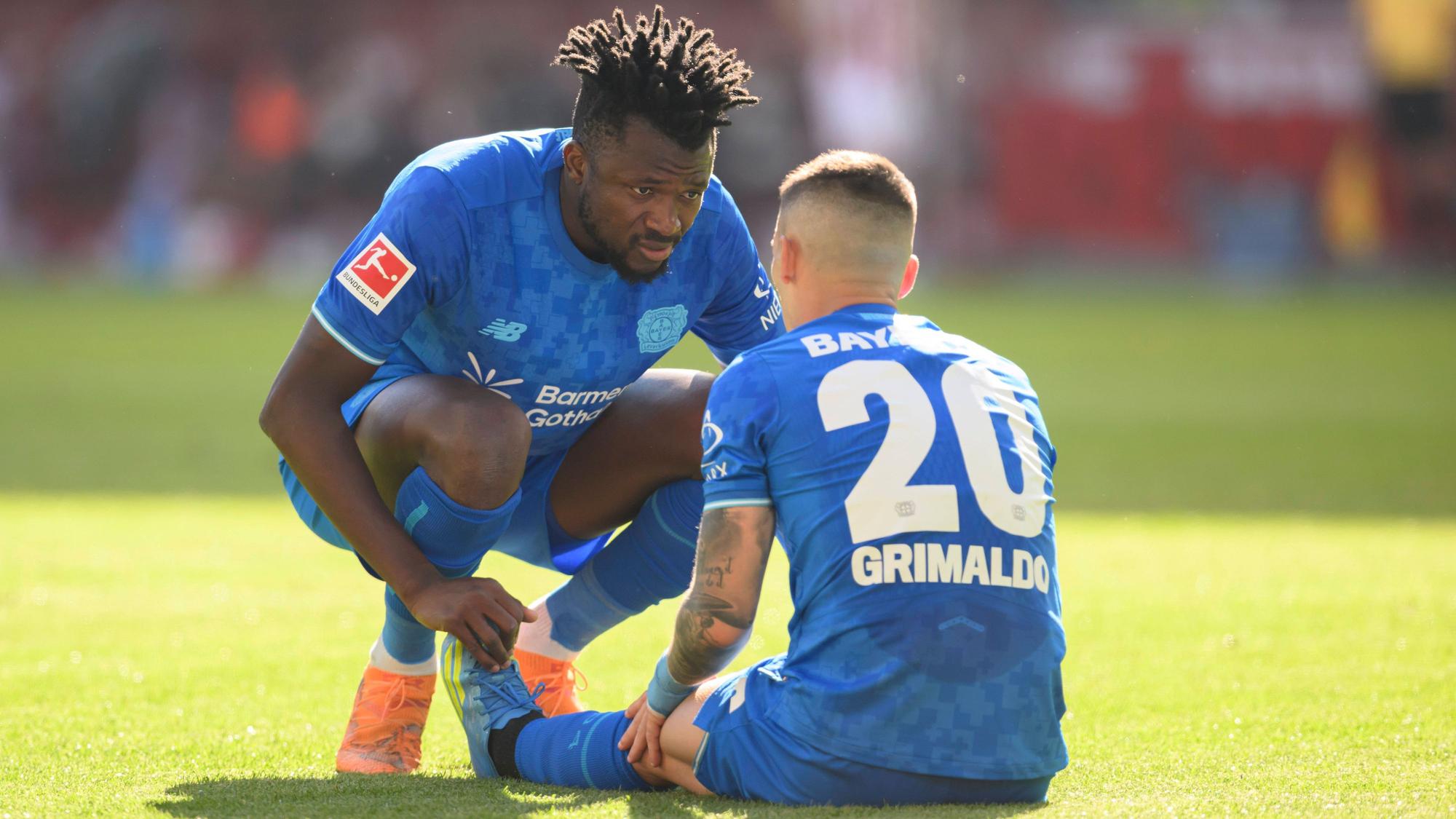 Alex Grimaldo Bayer Leverkusen sitzt am Boden, Edmond Tapsoba Bayer Leverkusen sieht nach ihm, Verletzung. Fussball 1. Bundesliga, 31.Spieltag, 1. FC Koeln - Bayer 04 Leverkusen. 1:2, am 25.04.2026 in Koeln/ Deutschland. DFL regulations prohibit any use of photographs as image sequences and/or quasi-video  *** Alex Grimaldo Bayer Leverkusen sits on the ground, Edmond Tapsoba Bayer Leverkusen looks after him, injury Football 1 Bundesliga, Matchday 31, 1 FC Koeln Bayer 04 Leverkusen 1 2, on 25 04 2026 in Koeln Germany DFL regulations prohibit any use of photographs as image sequences and or quasi video Â