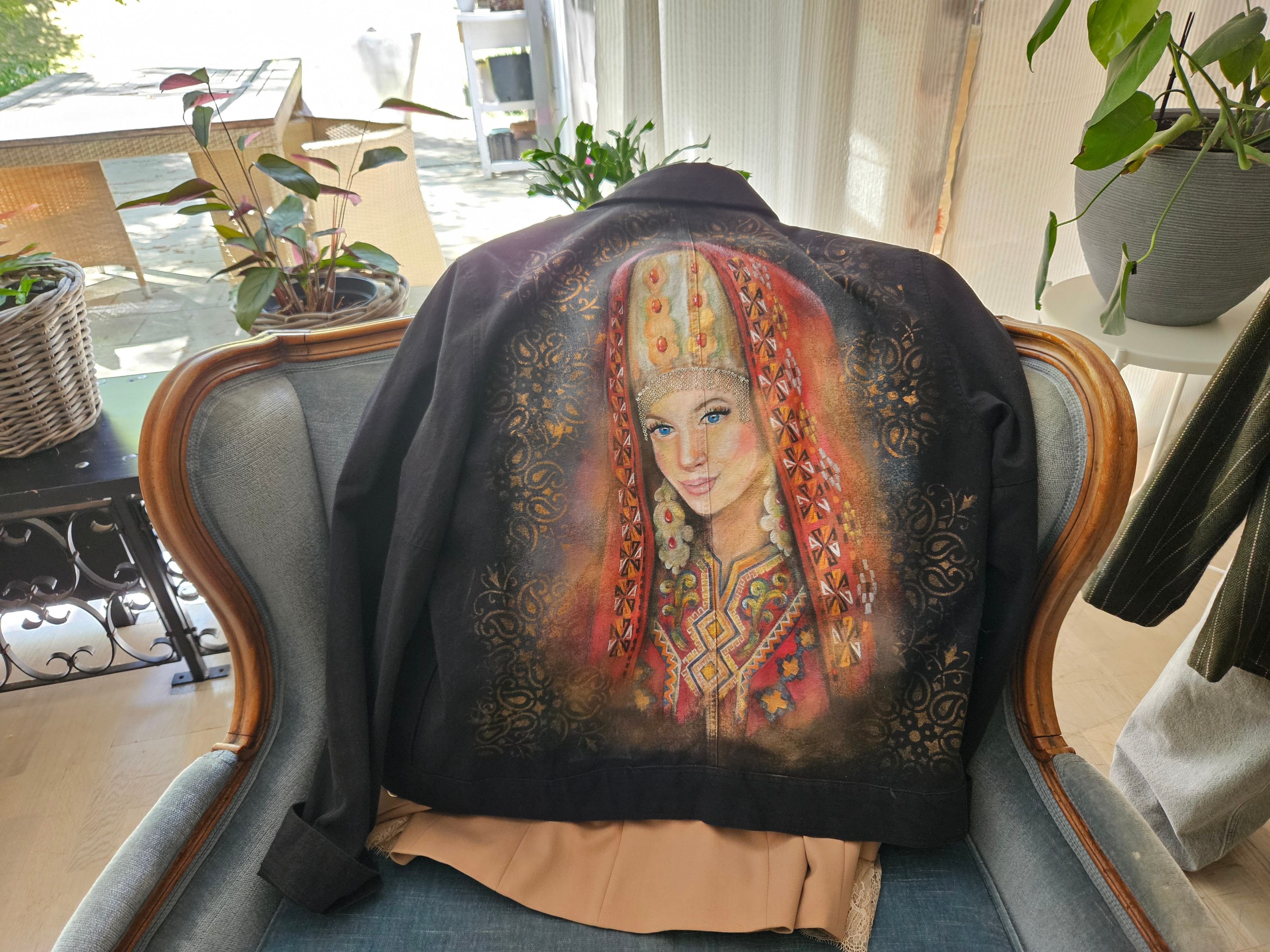 Das Foto zeigt eine Jacke, auf der eine Frau in Tracht abgebildet ist.