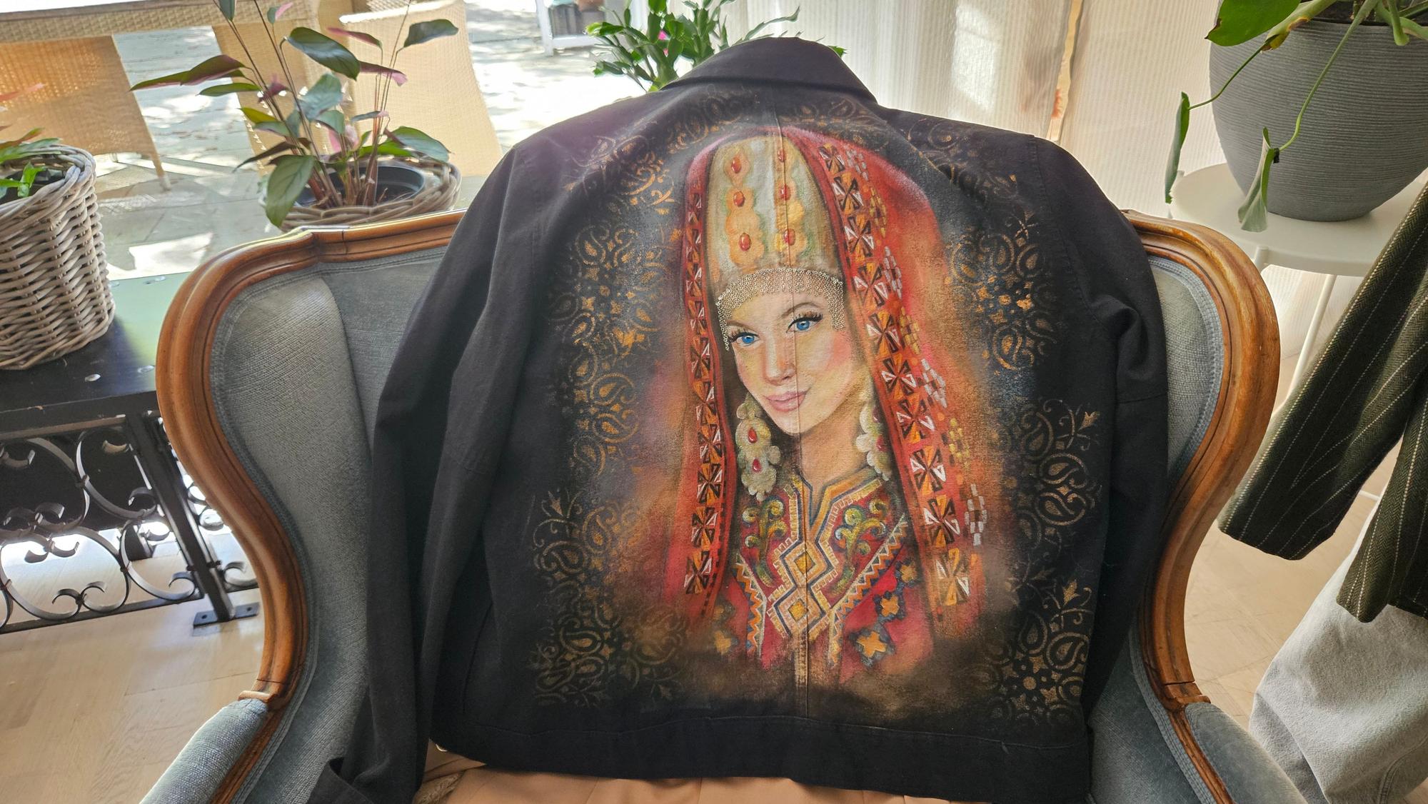 Das Foto zeigt eine Jacke, auf der eine Frau in Tracht abgebildet ist.