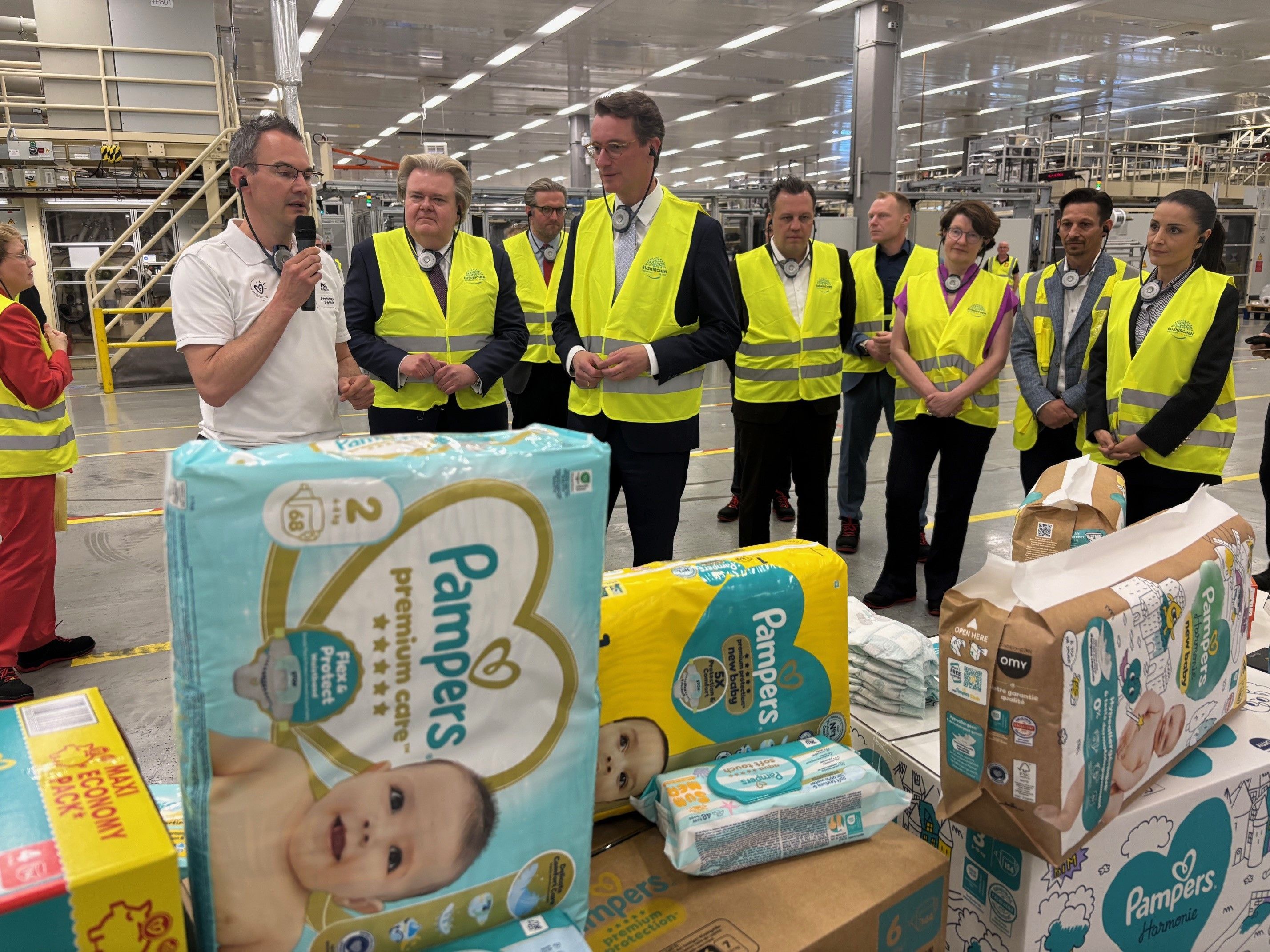 Hendrik Wüst mit einer Besuchergruppe bei der Führung im Procter & Gamble-Werk Euskirchen.