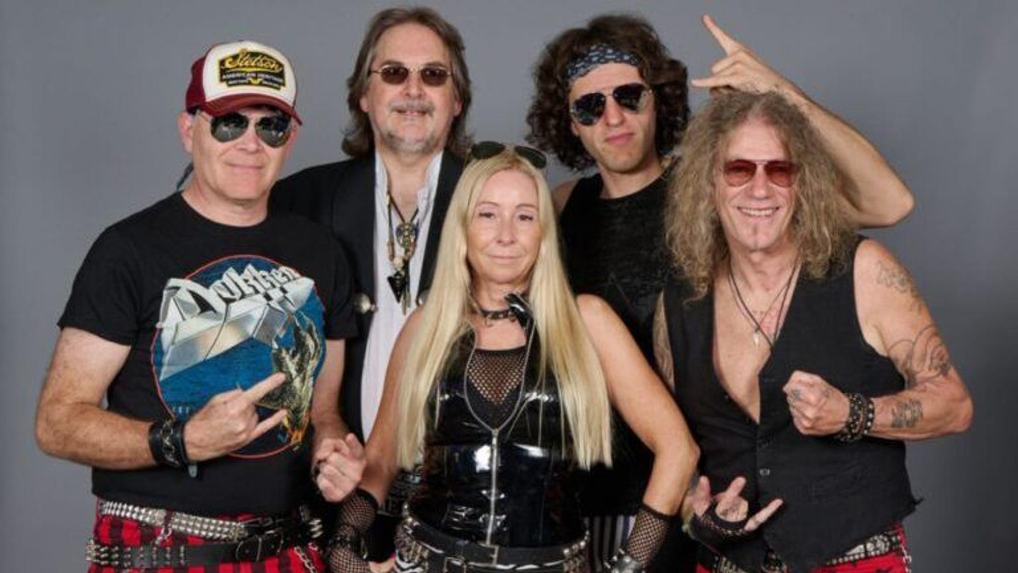 Die Musiker posieren in 80er-/90er-Outfits und blicken in die Kamera.