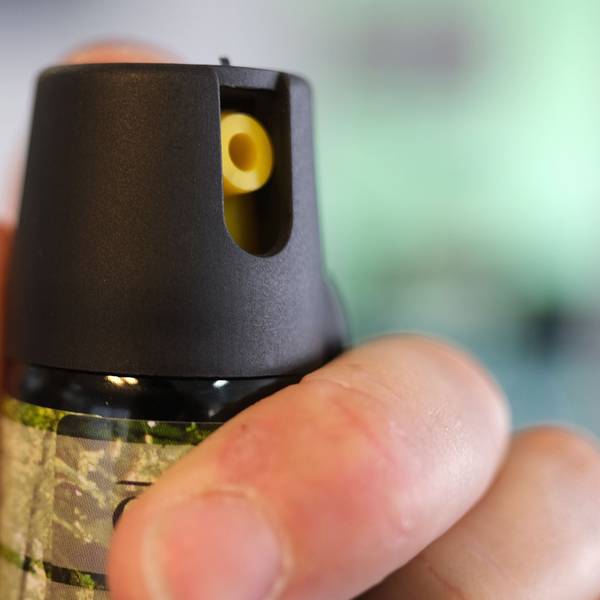 Eine Hand hält eine Kartusche mit Pfefferspray.