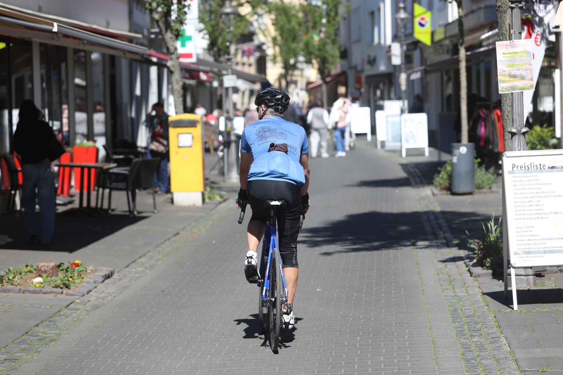 Ein Rennradfahrer fährt durch eine Fußgängerzone.