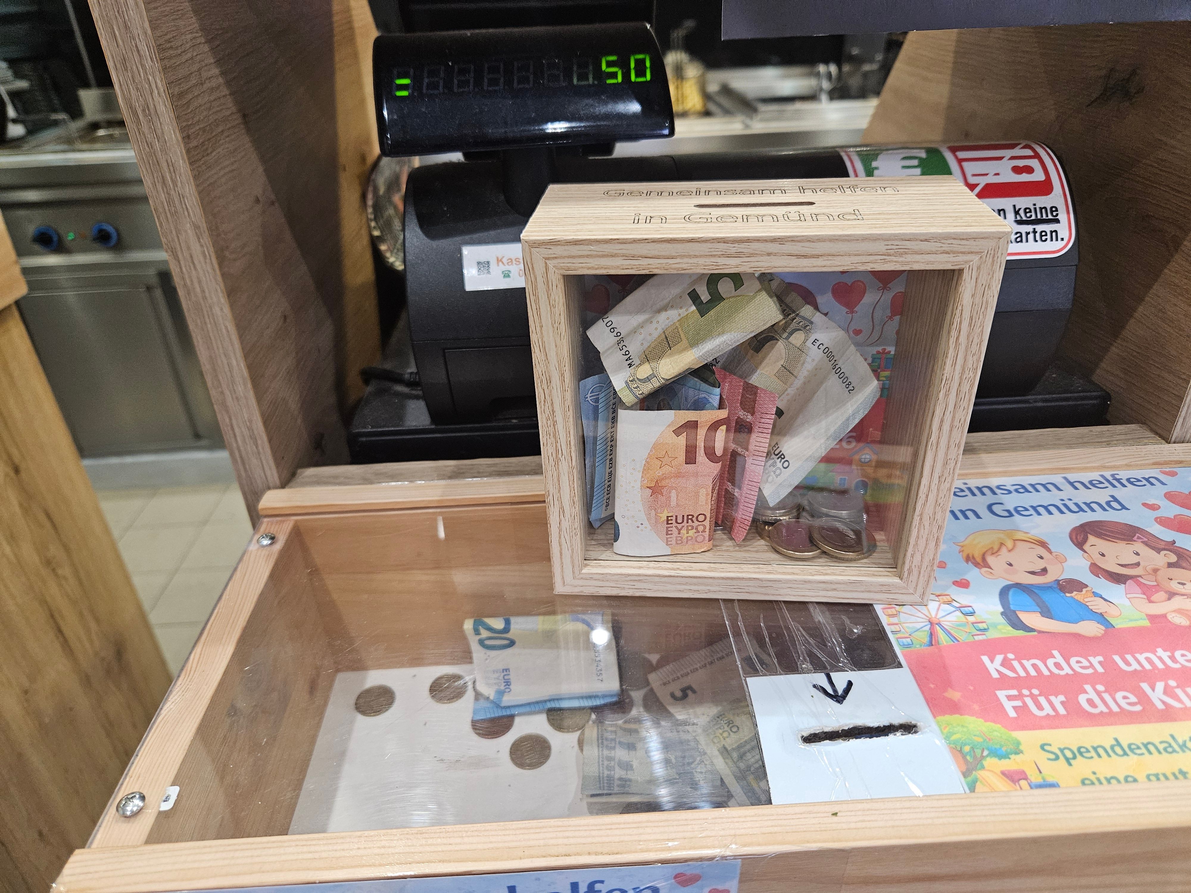 Das Bild zeigt zwei Boxen mit Geldscheinen und Münzgeld.
