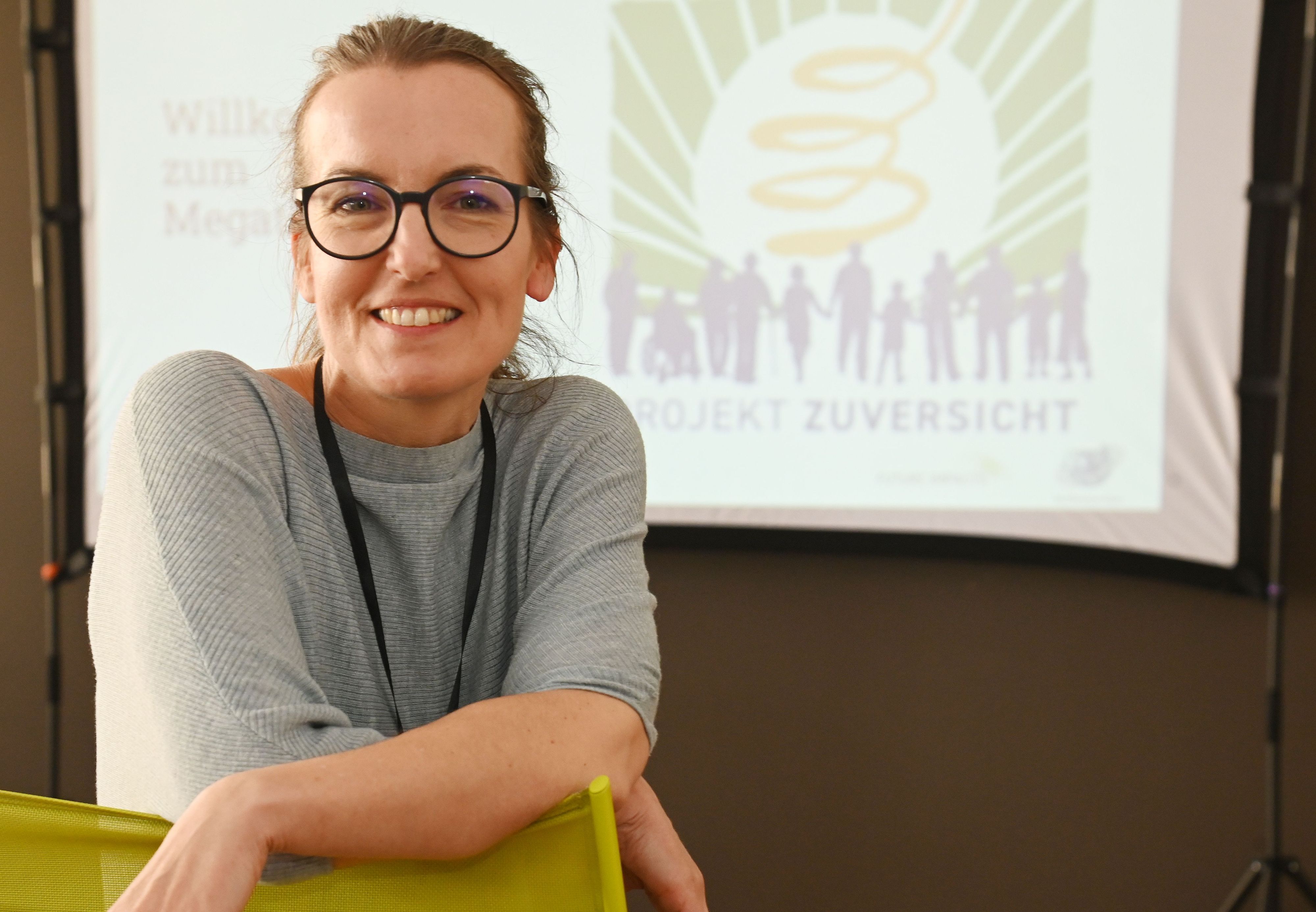 Eine Frau mit Brille lächelt in die Kamera.