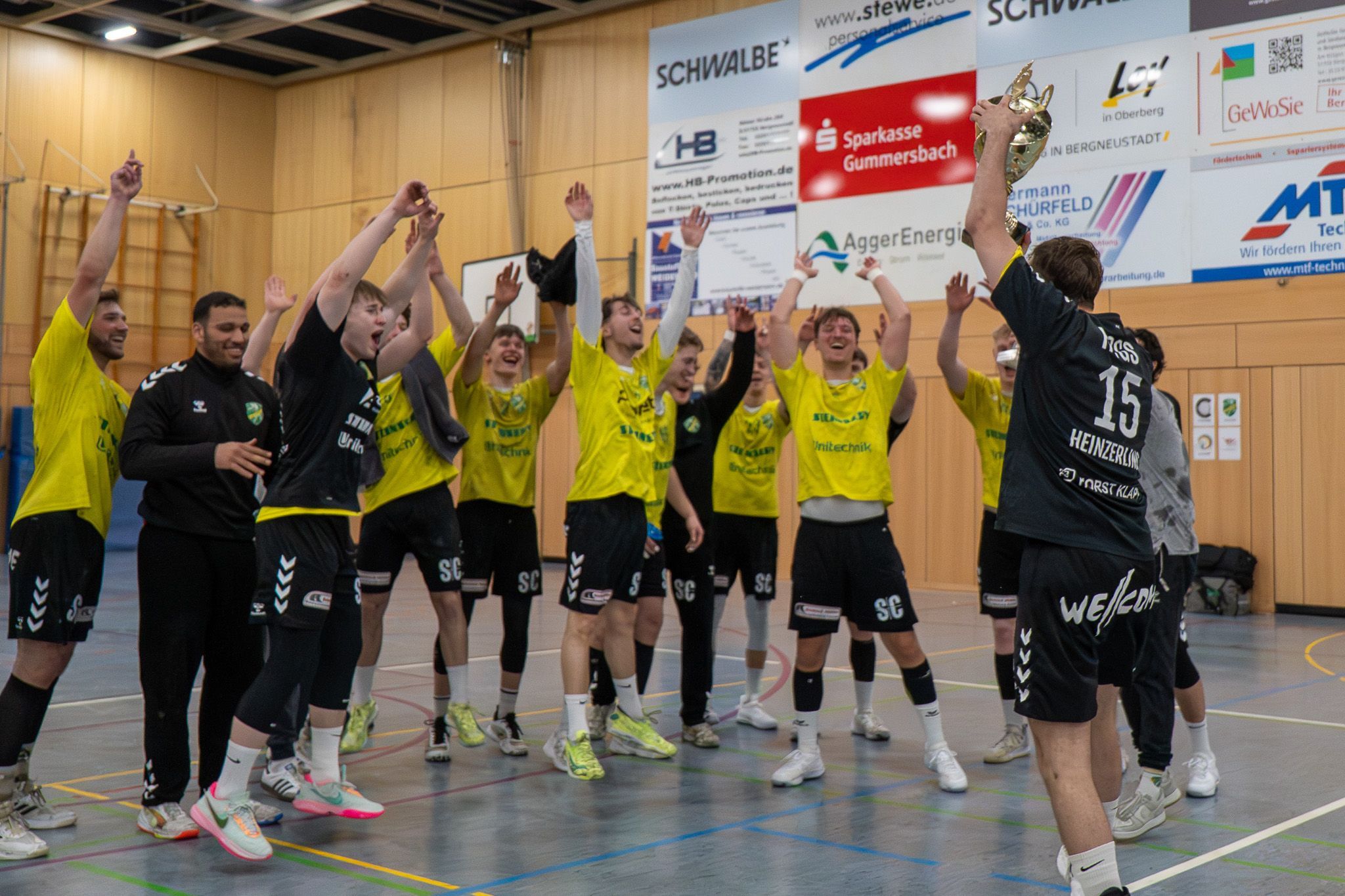 Die Handballer jubeln mit den Händen zum Himmel.