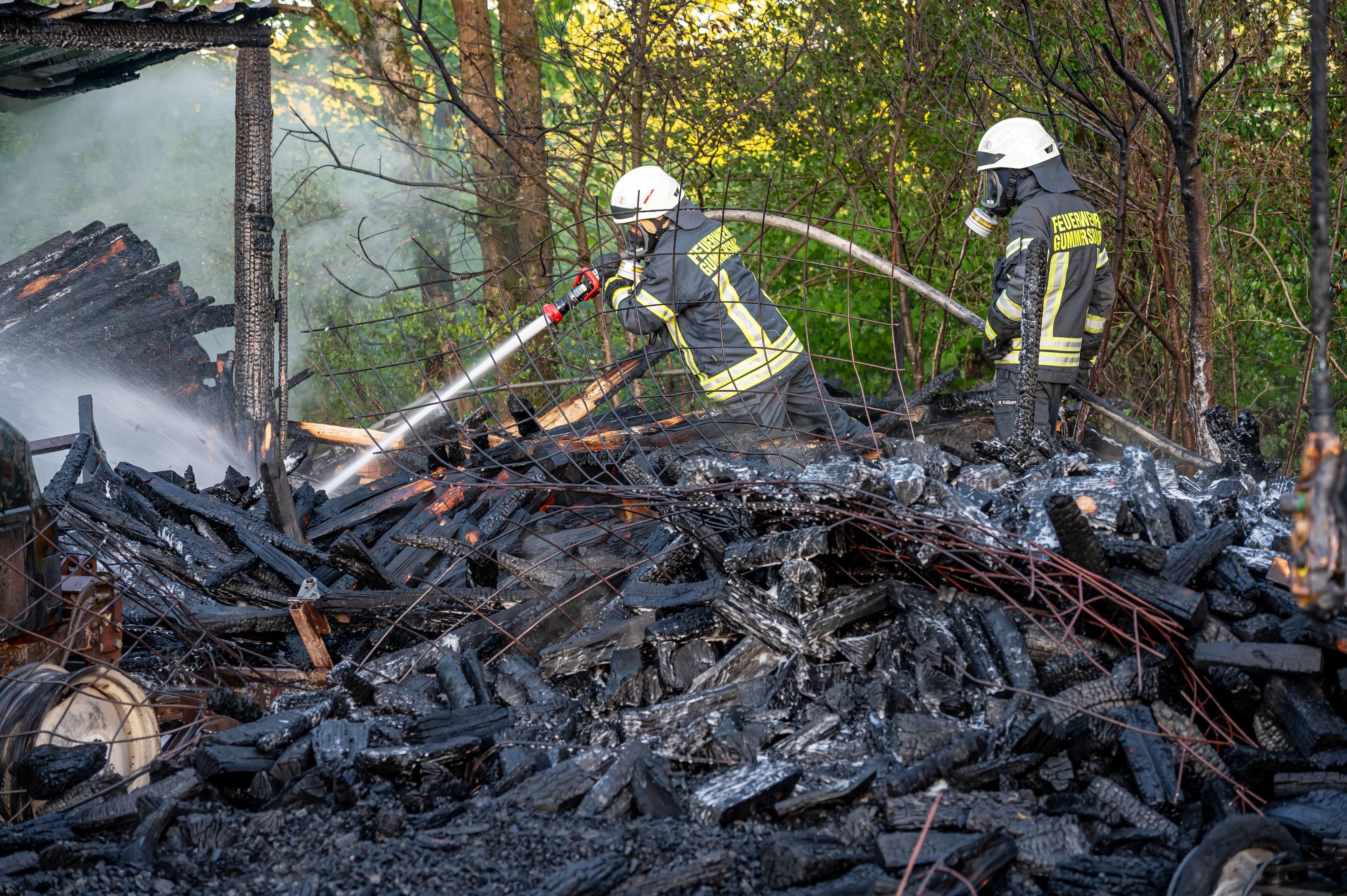 Feuerwehrleute löschen einen Schuppenbrand.