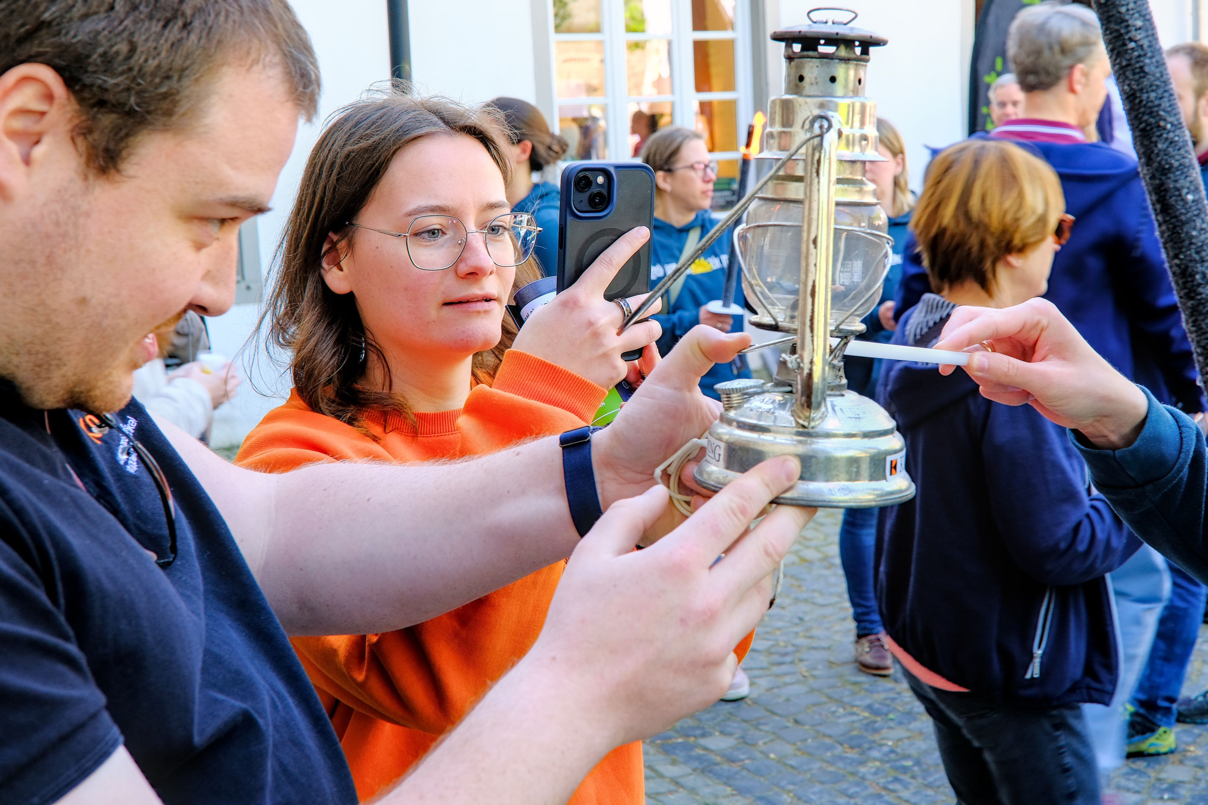 Das Foto zeigt, wie die Flamme weitergereicht wird
