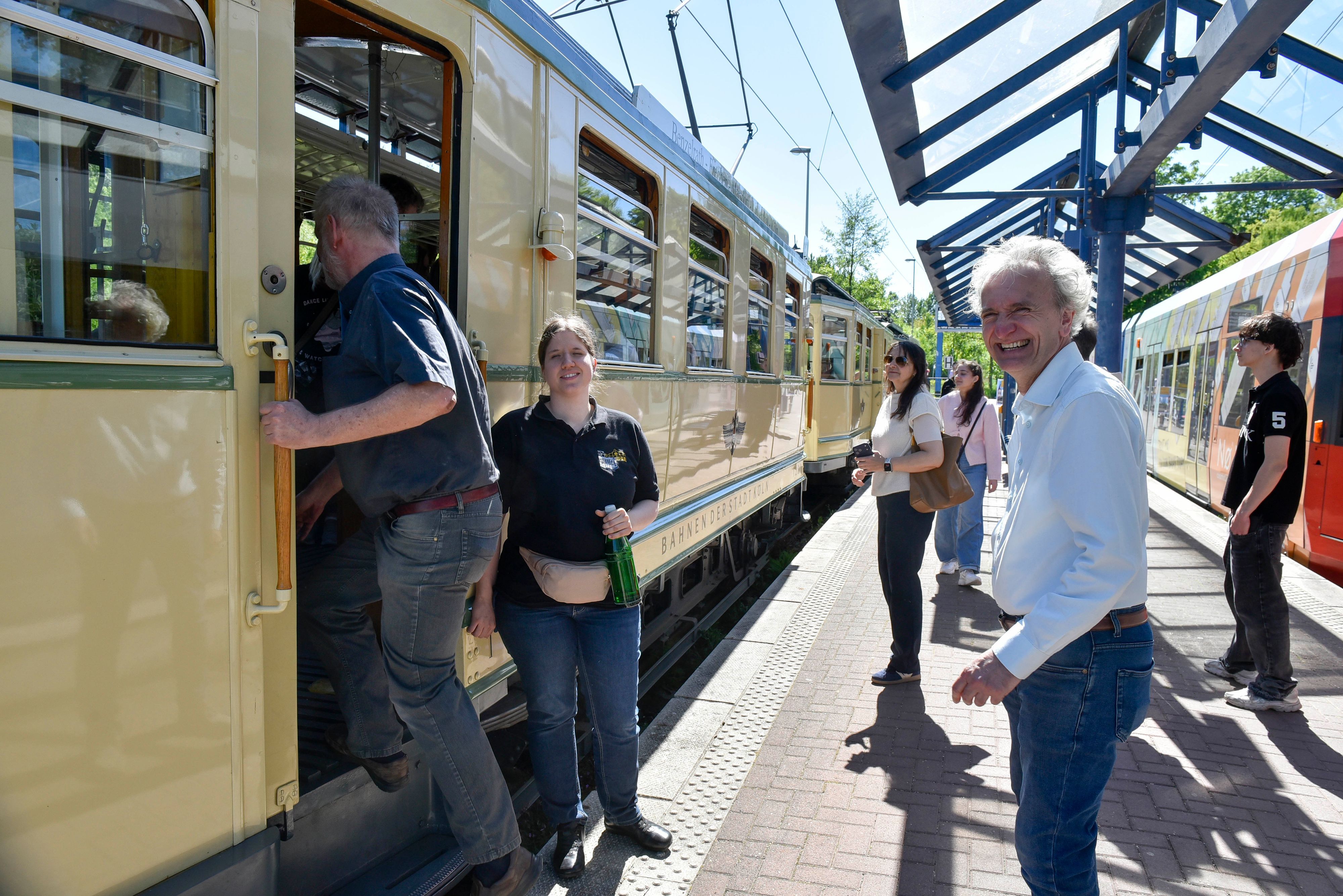 Auf dem Bild sind Personen zu sehen, die in die historische Straßenbahn einsteigen.