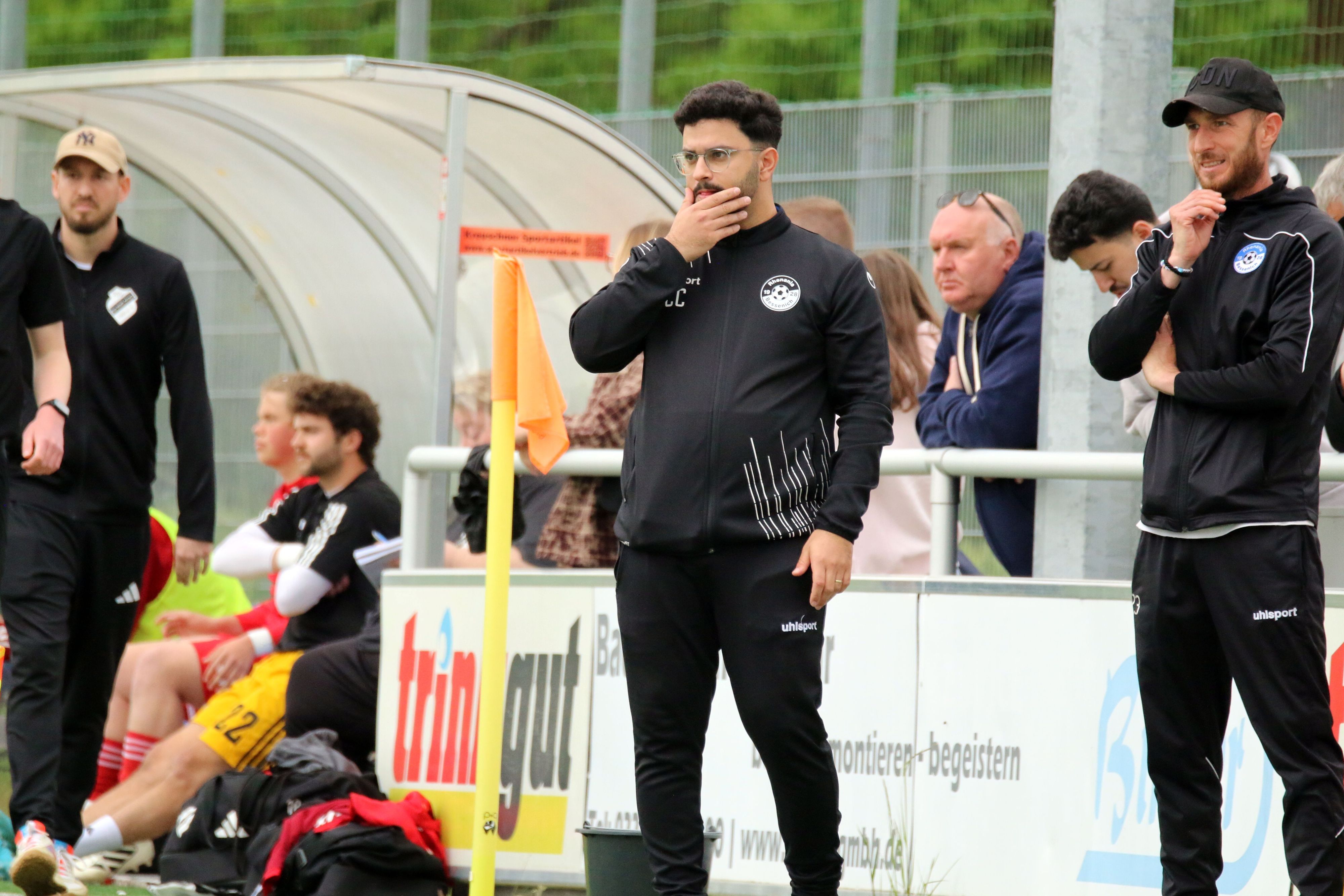 Bessenichs Trainer Can Celik greift sich mit der Hand ins Gesicht. Neben ihm steht Ex-Profi Moritz Hartmann.