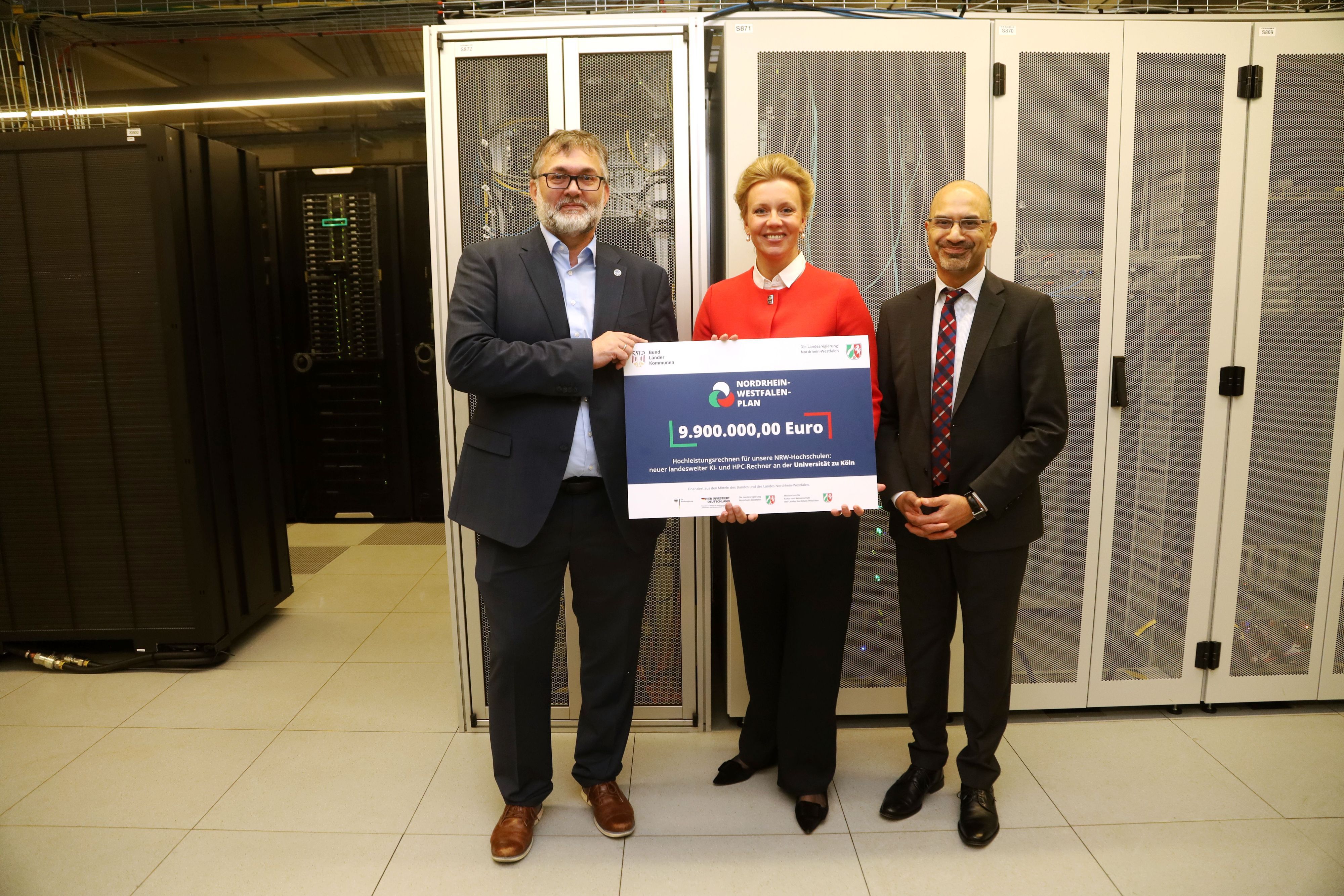 Mehr Rechenpower für KI: Die Universität zu Köln baut das Hochleistungsrechnen für nordrhein-westfälische Hochschulen aus. Ministerin Ina Brandes überreicht der Uni eine Förderzusage für ein High Performance Computing Basiscluster an Joybrato Mukherjee (rechts) und Stefan Wesner.  Foto: Arton Krasniqi