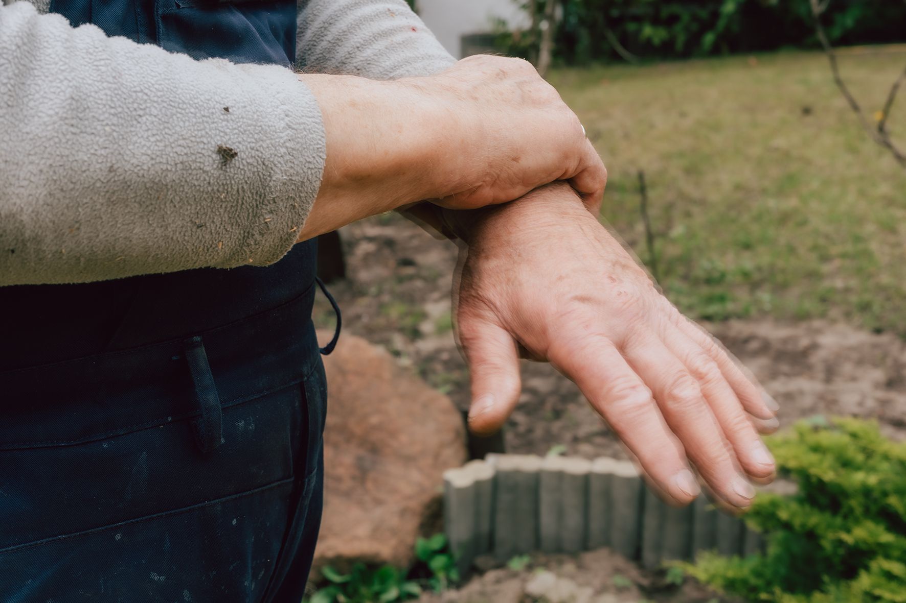 Zu sehen ist eine Hand, die ein Handgelenk umschließt.
