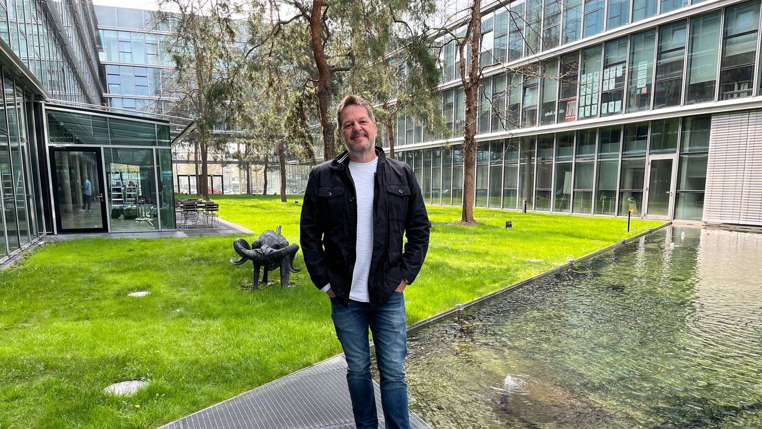 Linus Geschke steht in einem grünen Innenhof