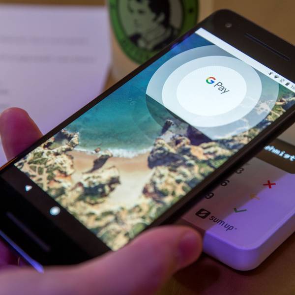 Ein Gast demonstriert mit einem Smartphone und der App des neuen Bezahldienstes Google Pay in einem Cafe das Bezahlen mit dem Handy.
