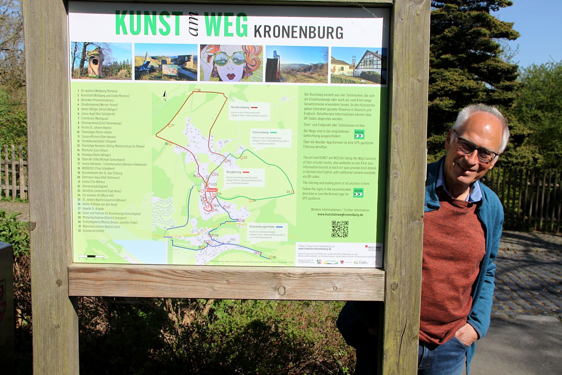 Das Bild zeigt den Obengenannten. Peter Igelmund steht seitlich neben einer Hinweistafel.