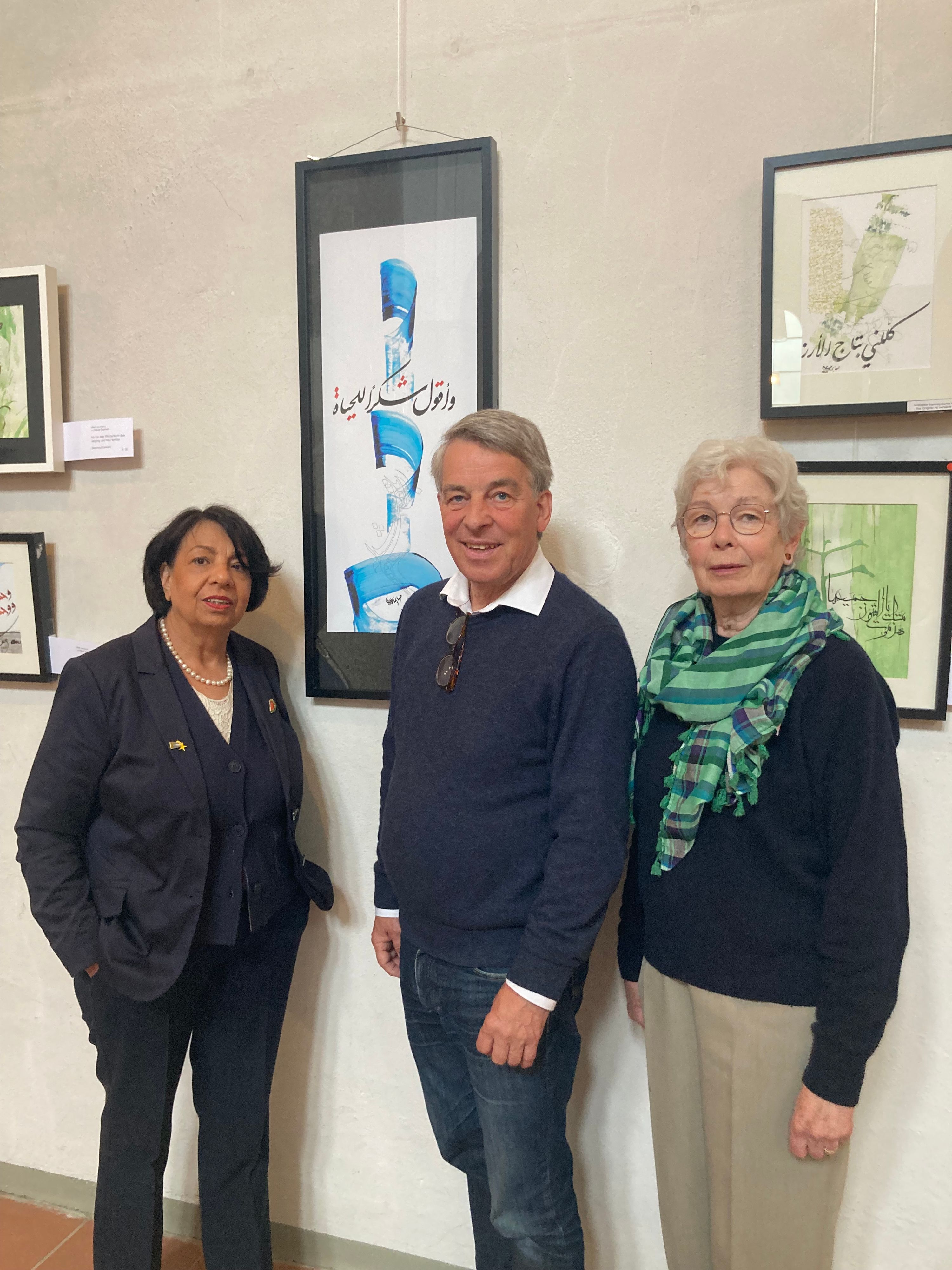 Suraya Hoffmann, Albrecht Schröter und Maria Meiwes vor Bildern der Kalligrafie-Ausstellung in St. Maternus.