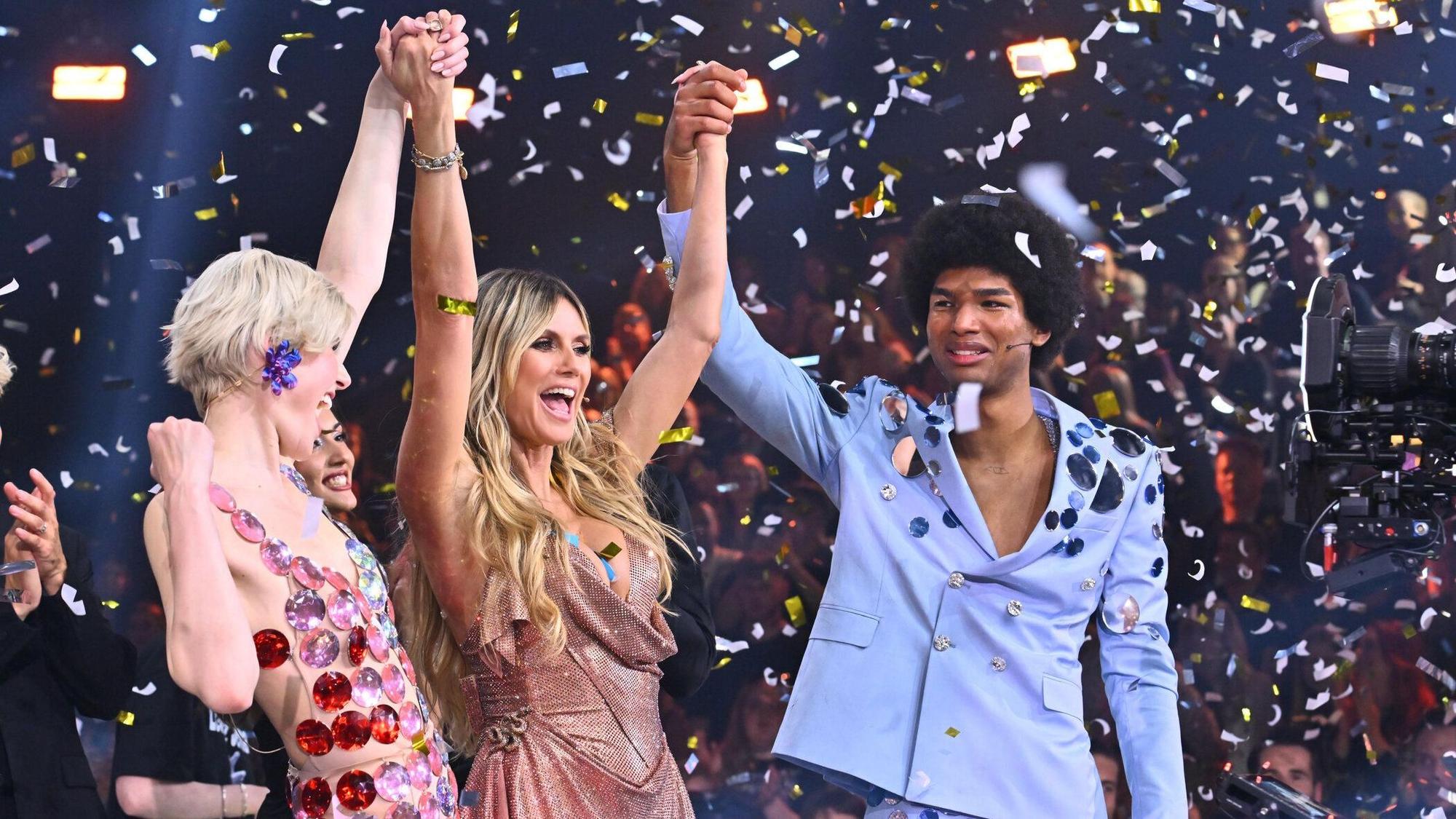 Heidi Klum (M) hält die Hände von Lea und Jermaine, den Siegern der 19. Ausgabe von „Germany's Next Topmodel“, hoch.