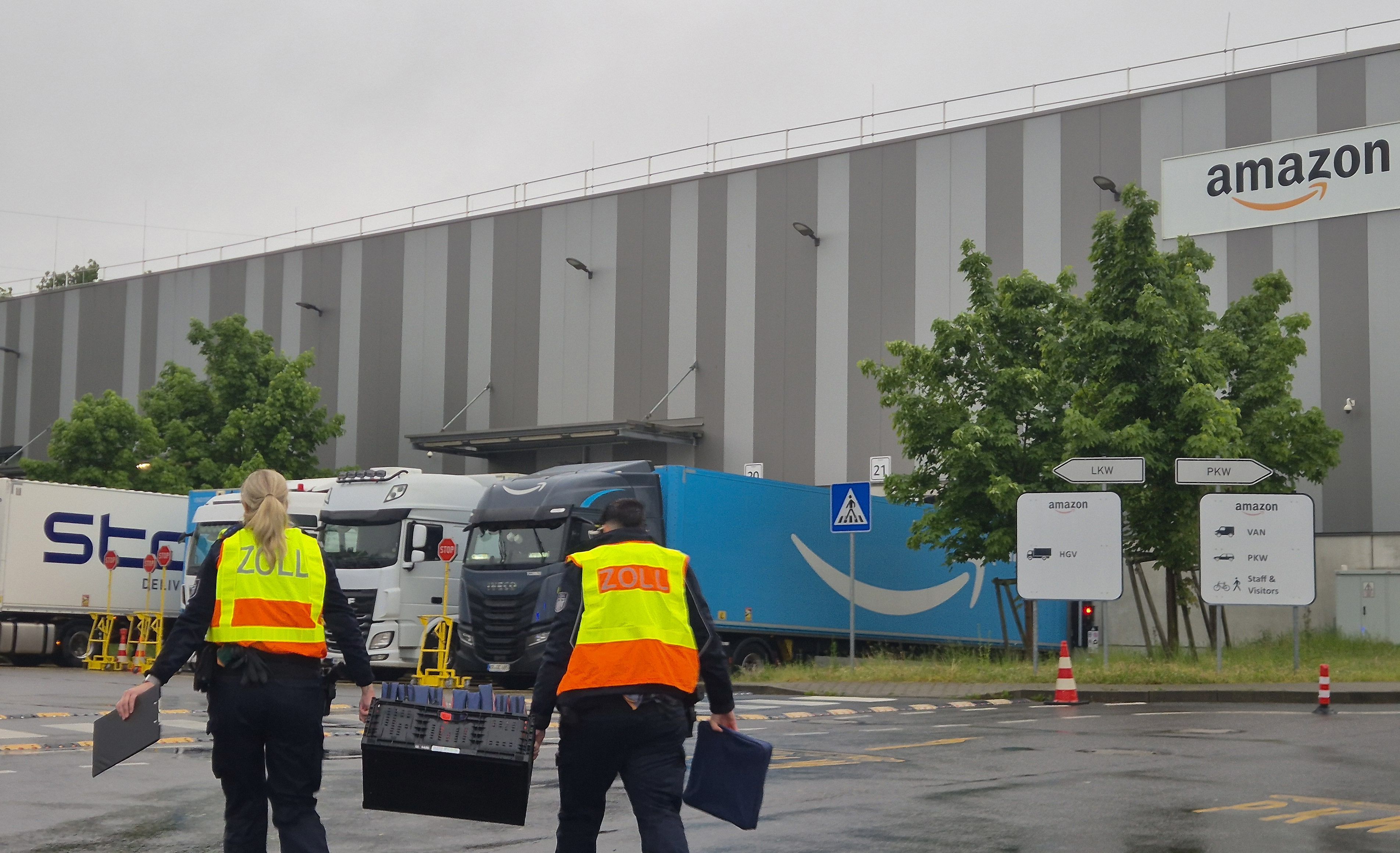 Zollbeamte gehen auf das Gelände eines Logistikunternehmens. Geprüft werden Verteilzentren verschiedener großer Paket-Dienstleister.