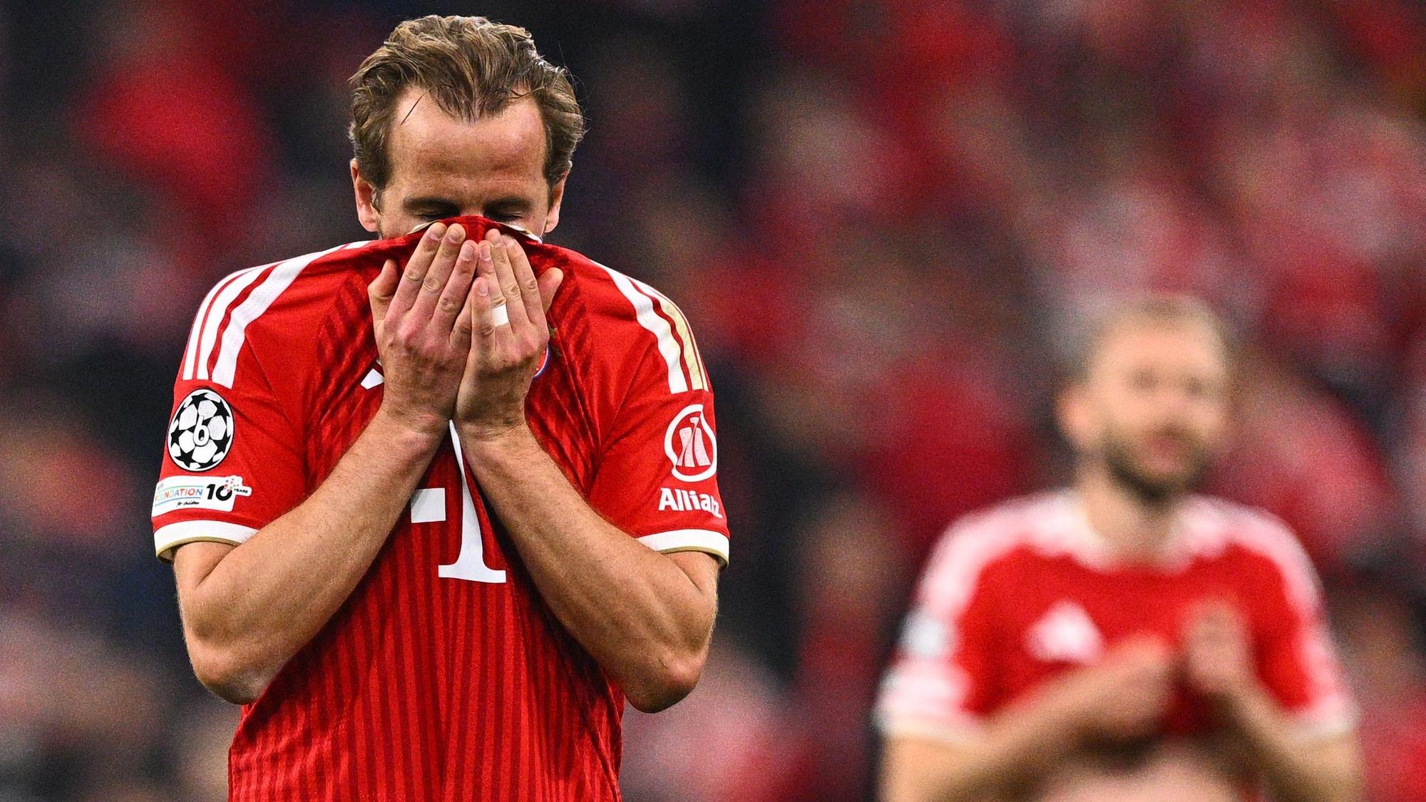 Harry Kane hält sich das Trikot vors Gesicht.