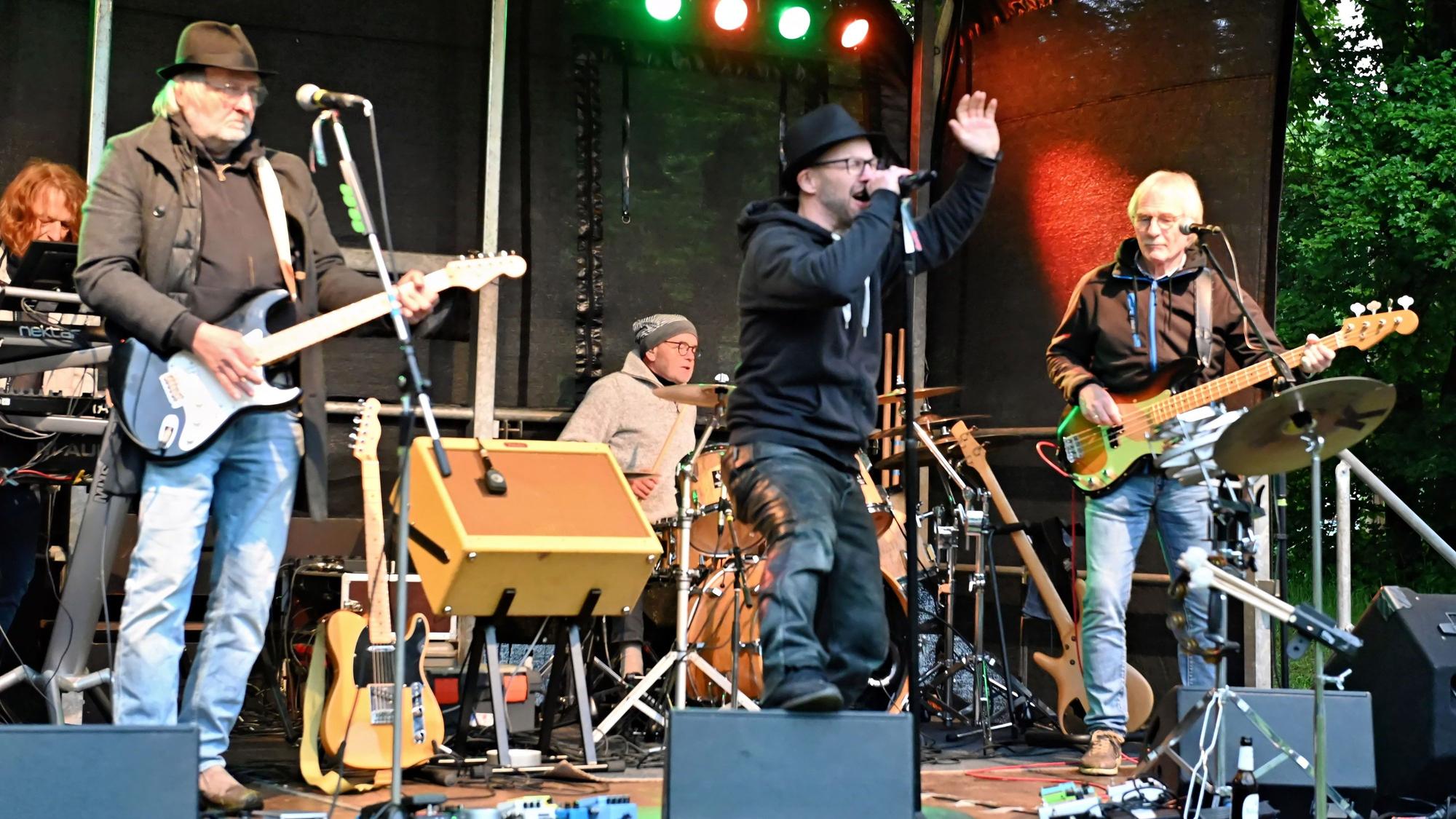 Drei Musiker stehen auf der Bühne.