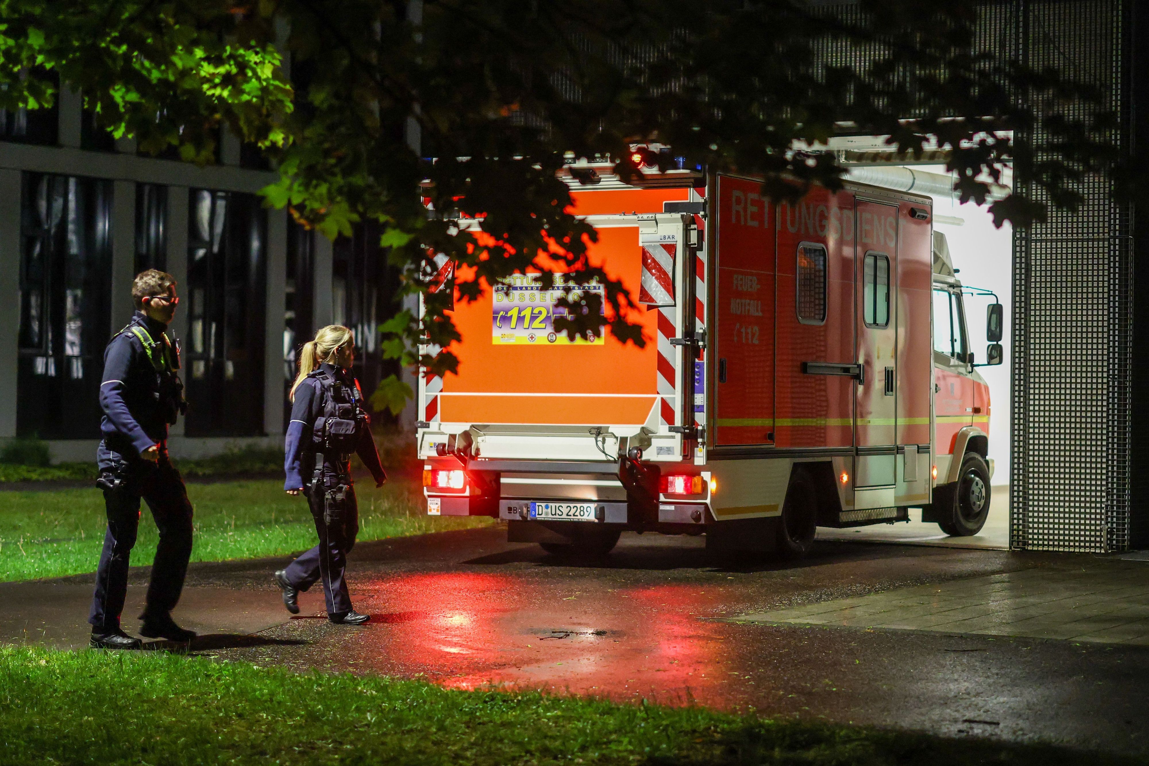 Polizisten am Mittwochabend (6. Mai) bei einem Rettungswagen, der eine deutsche Patientin in das Infektionszentrum der Uniklinik Düsseldorf bringt.