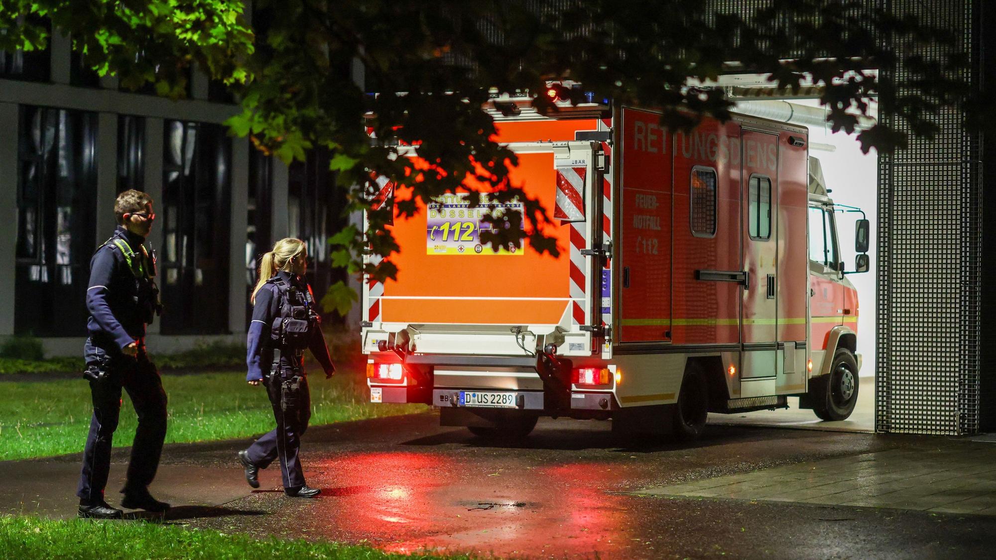 Polizisten am Mittwochabend (6. Mai) bei einem Rettungswagen, der eine deutsche Patientin in das Infektionszentrum der Uniklinik Düsseldorf bringt.