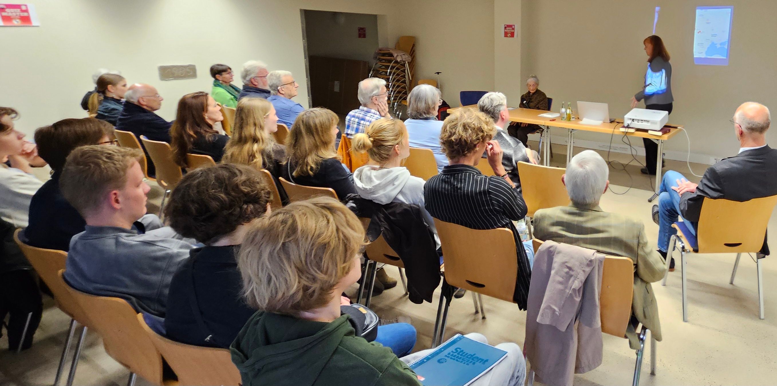 Man sieht Publikum bei einem Literaturgespräch von hinten fotografiert.