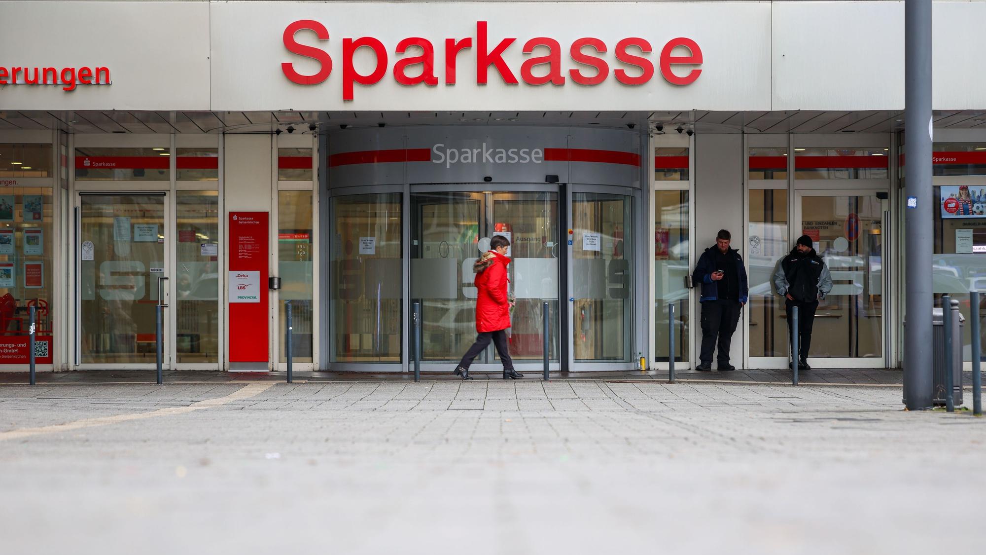 Security-Mitarbeiter stehen vor der Sparkasse Gelsenkirchen, die auf dem Archivbild noch geschlossen ist.