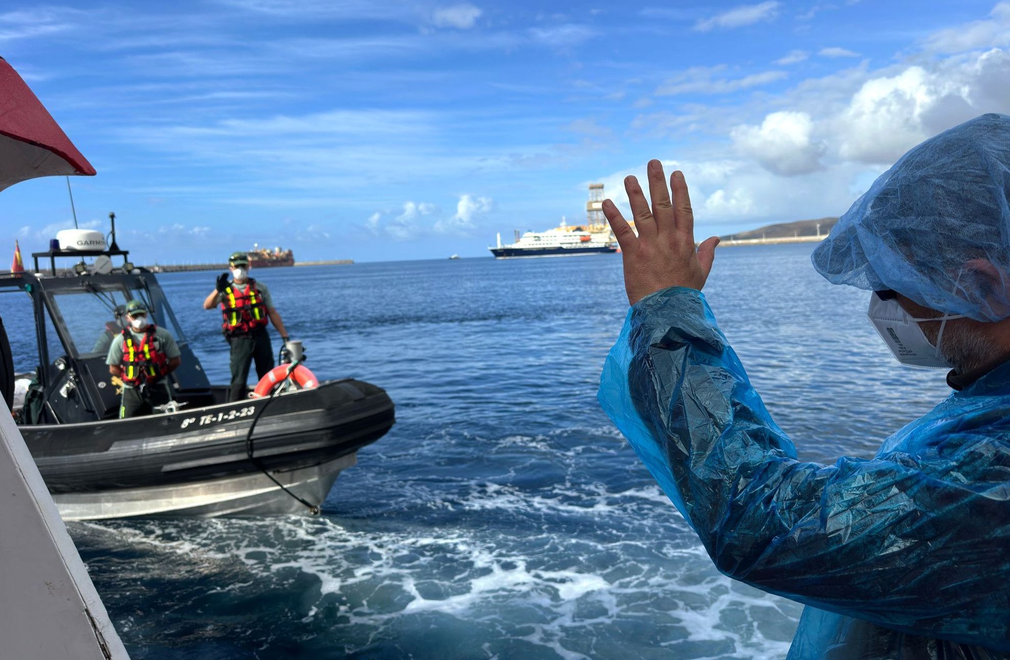 Teneriffa: Ein Person (r.) winkt Beamten der Guardia Civil zu, als sie am Sonntag (10. Mai) von dem vom Hantavirus befallenen Kreuzfahrtschiff MV Hondius im Hafen von Granadilla ausgeschifft wird.
