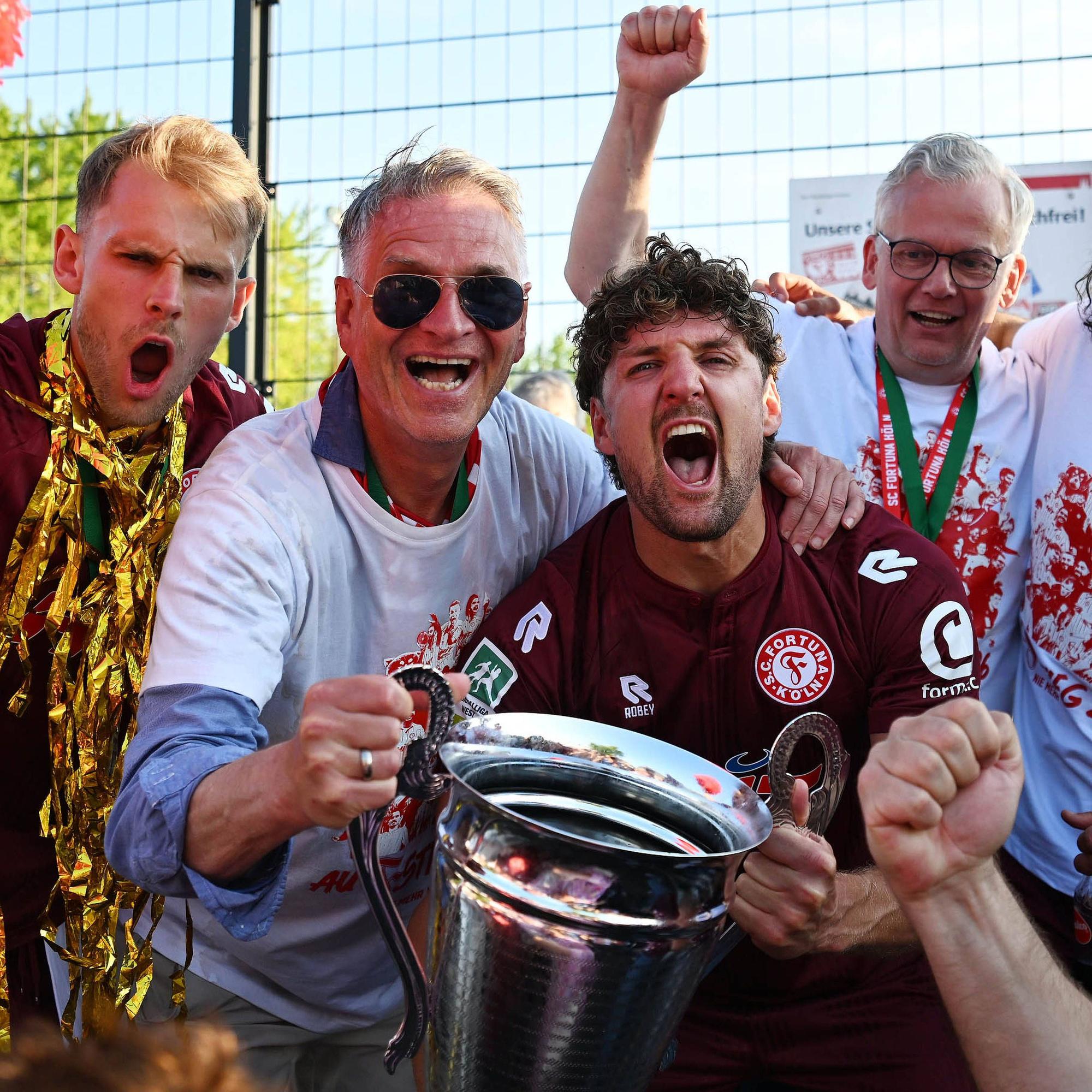 Fortuna Köln ist aufgestiegen. Feier im Südstadion nach dem Schlusspfiff. Die Spieler Georg Strauch und Enzo Wirtz mit Fortuna-Präsident Hanns-Jörg Westendorf (2.v.l.).