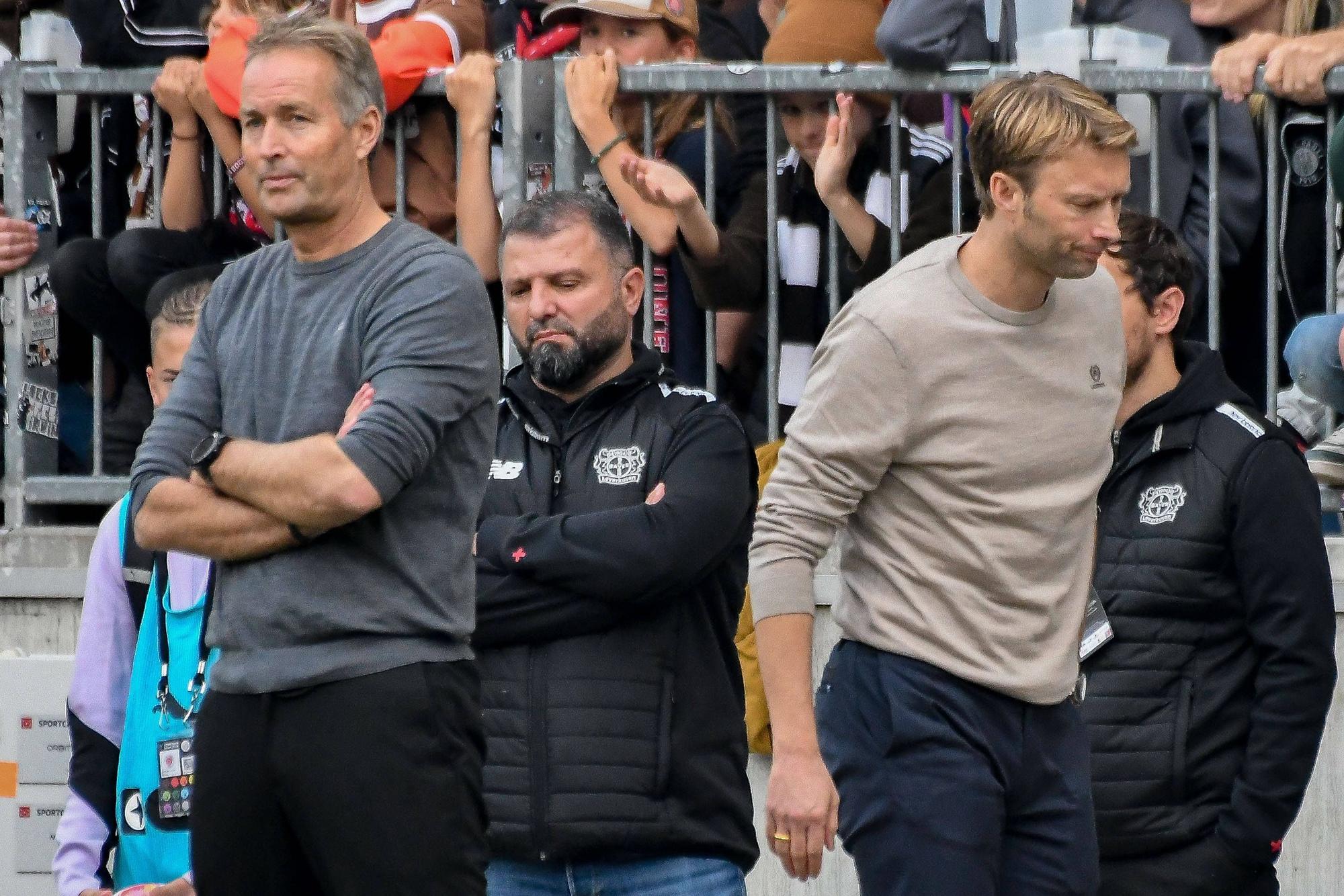 Kasper Hjulmand und Simon Rolfes drehen sich gegenseitig den Rücken zu.