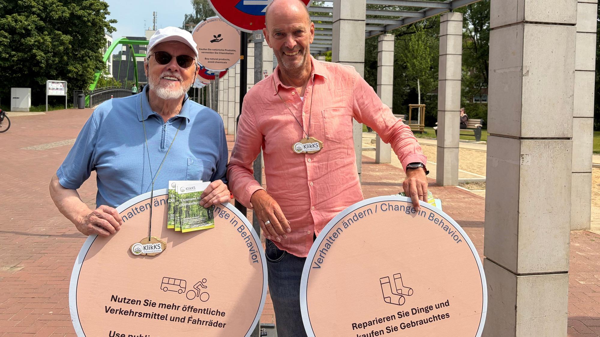 Friedrich Rohdenburg (l) und Hans-Peter Stupp mit den Verkehrsschildern für nachhaltiges Verhalten.