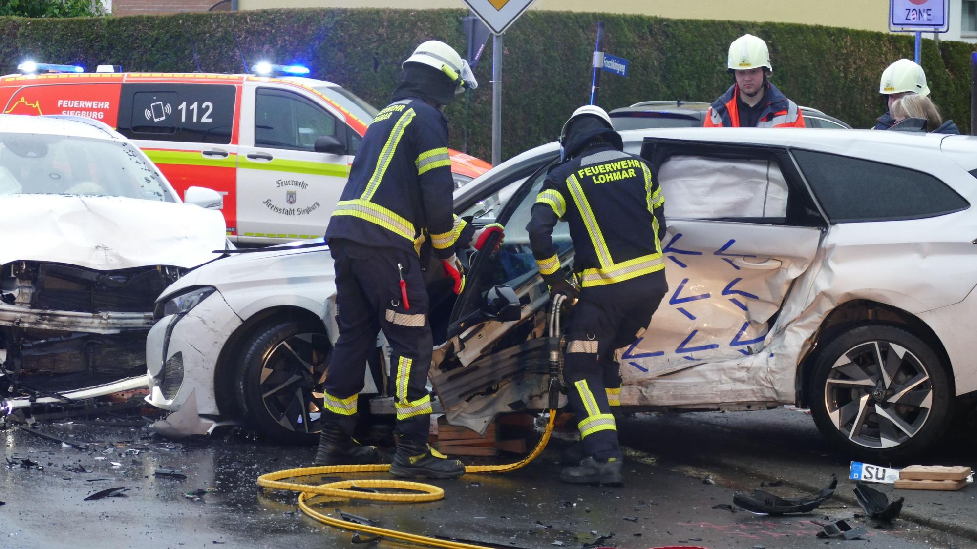 Feuerwehrleute arbeiten an einem Autowrack.