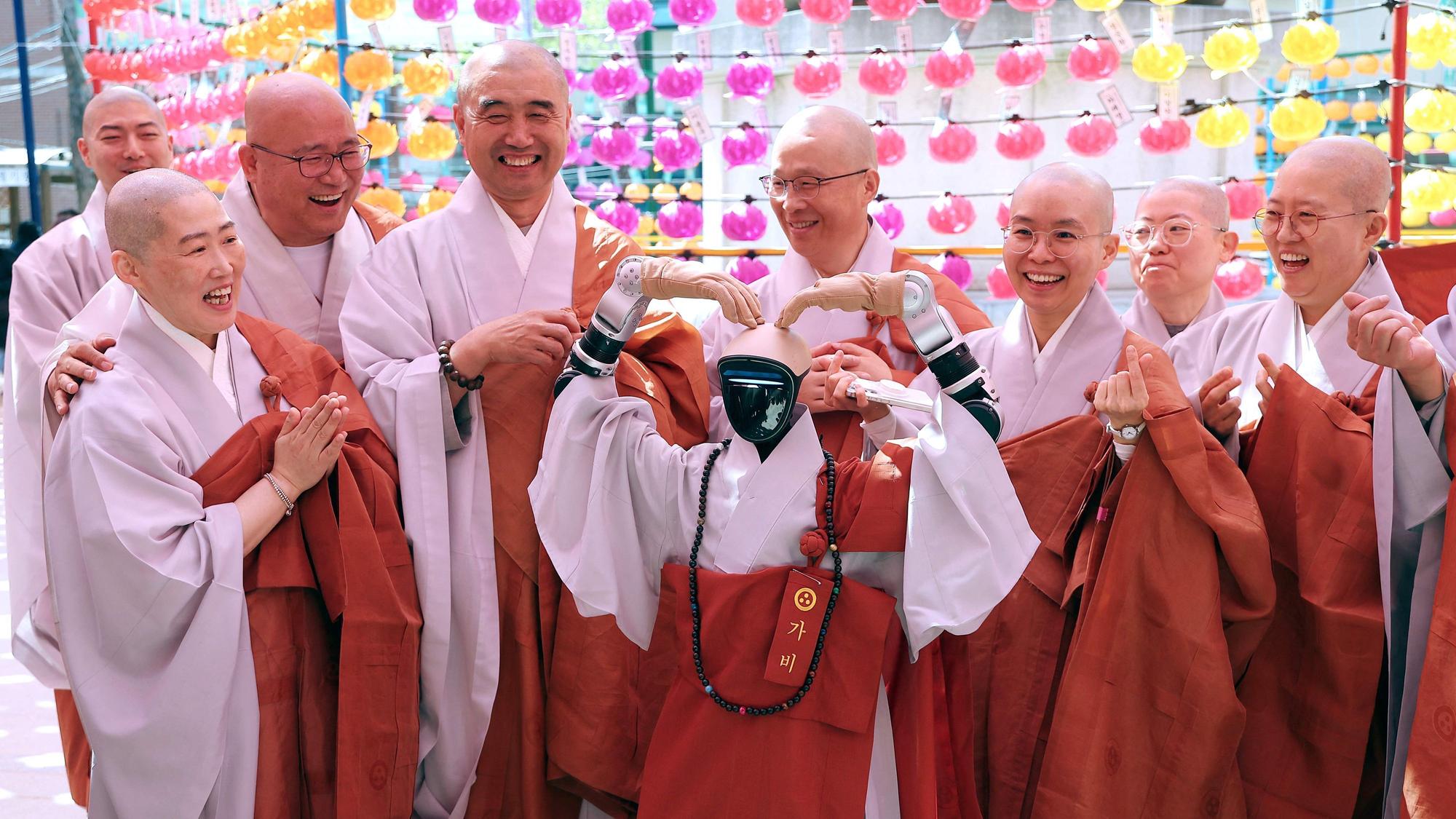 Gabi (C), a humanoid robot dressed as a Buddhist monk, poses with Buddhist monks as it attends an ordination ceremony as part of celebrations for the upcoming Buddha's birthday at Jogye Temple in Seoul on May 6, 2026.
