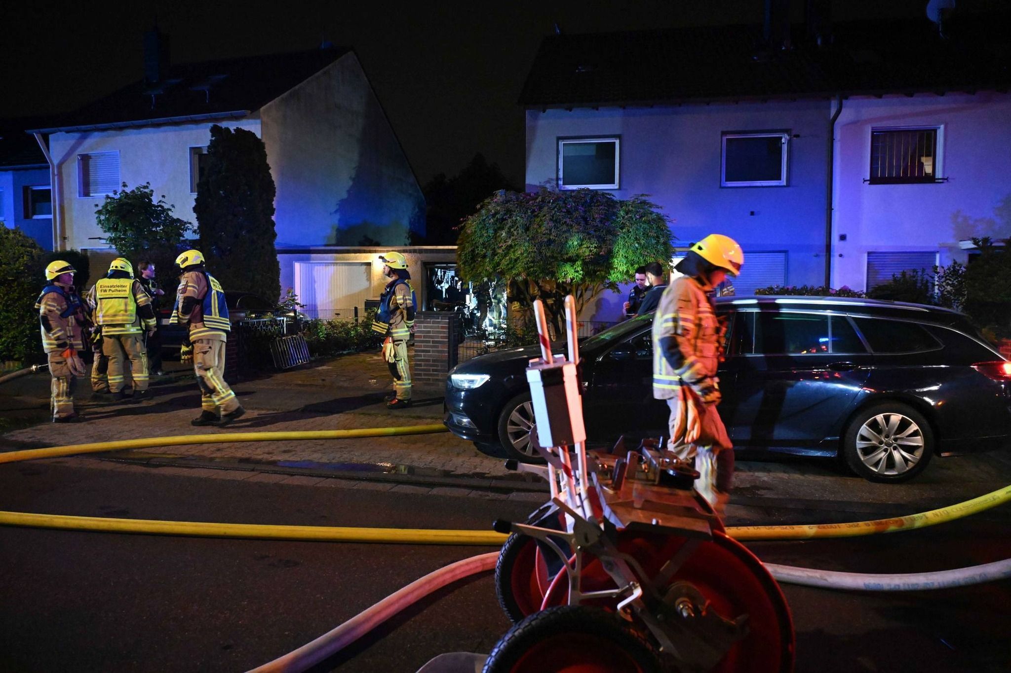 Auf dem Foto sind Feuerwehrleute vor einem Wohnhaus zu sehen.