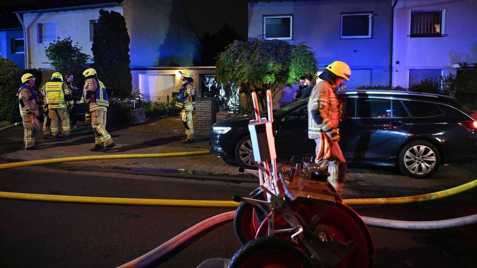 Auf dem Foto sind Feuerwehrleute vor einem Wohnhaus zu sehen.