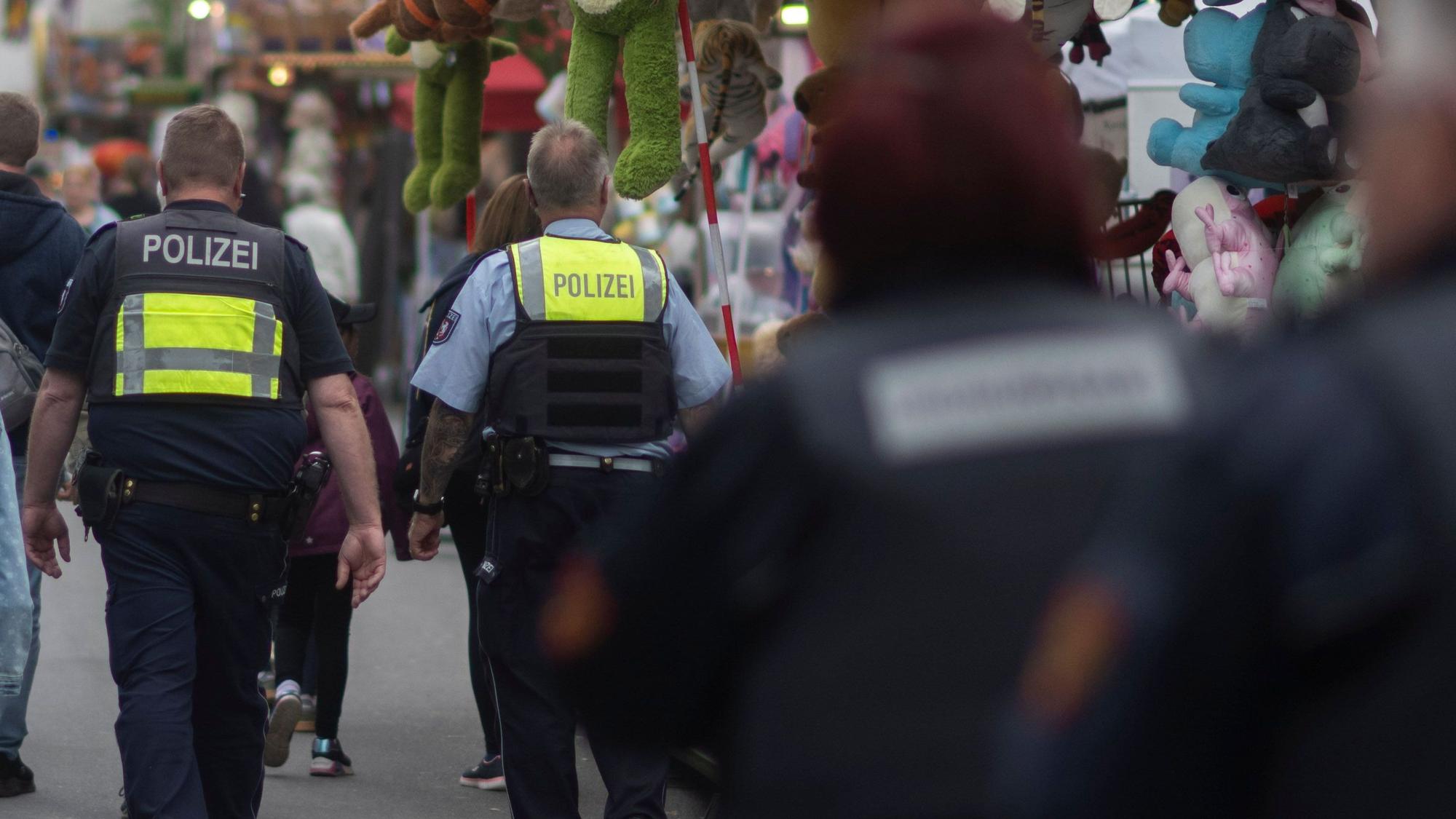 Das Bild zeigt Mitarbeitende des Ordnungsamts und der Polizei, während sie auf der Kirmes Streife gehen.