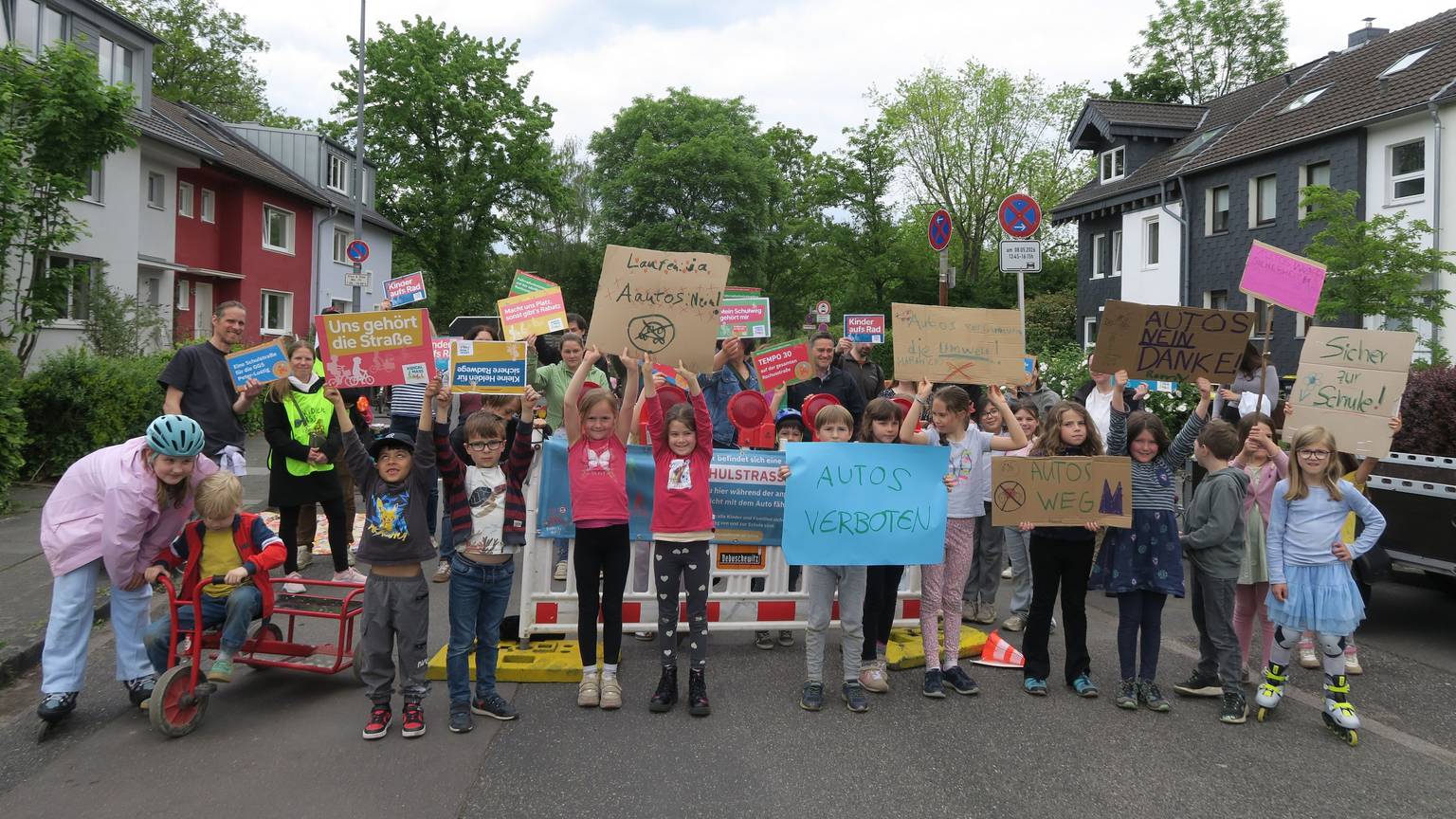 Kinder mit Plakaten und Transparenten stehen auf einer Straße.