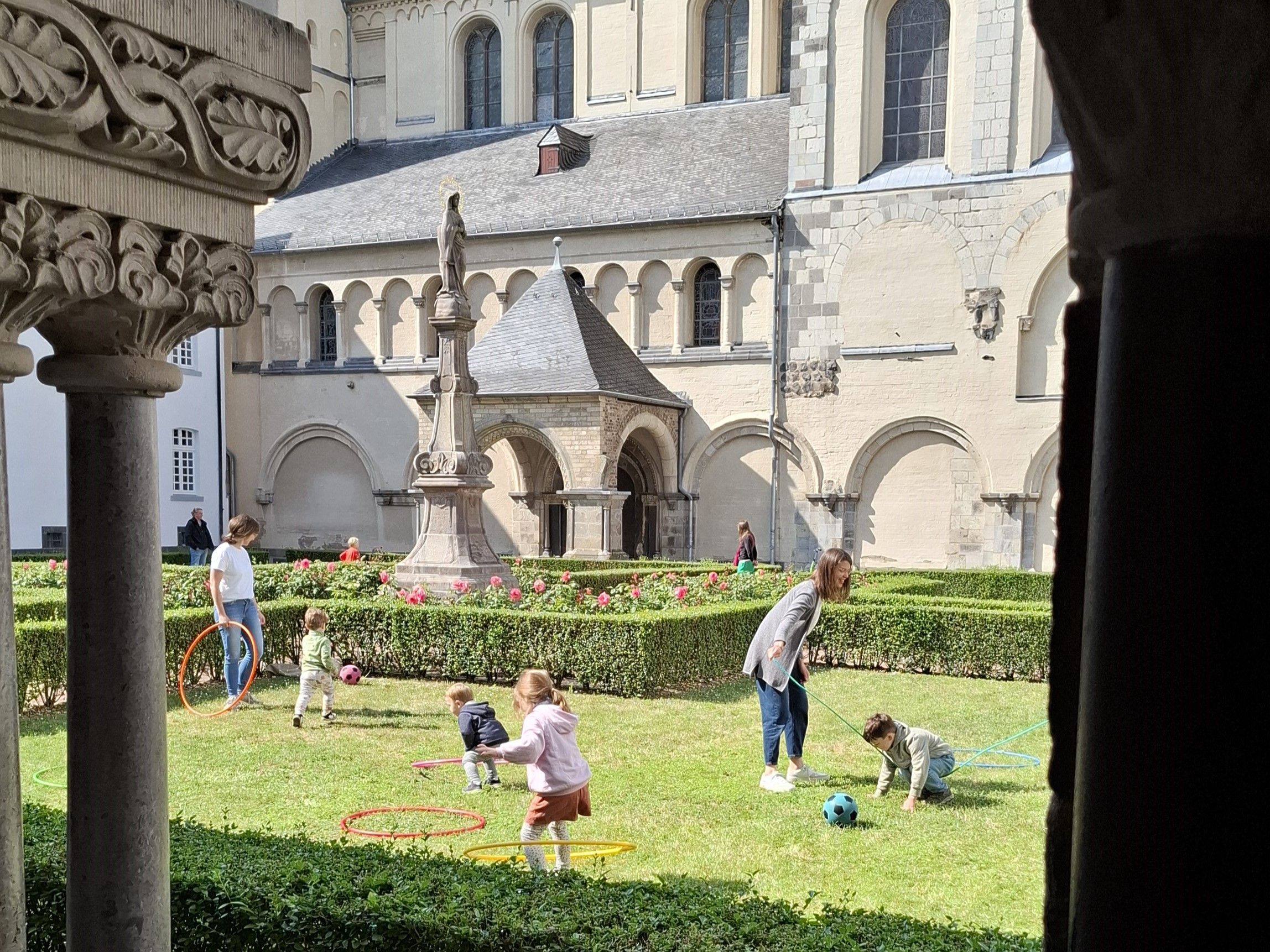 Das Foto zeigt spielende Kinder im Klostergarten der Abtei Brauweiler.