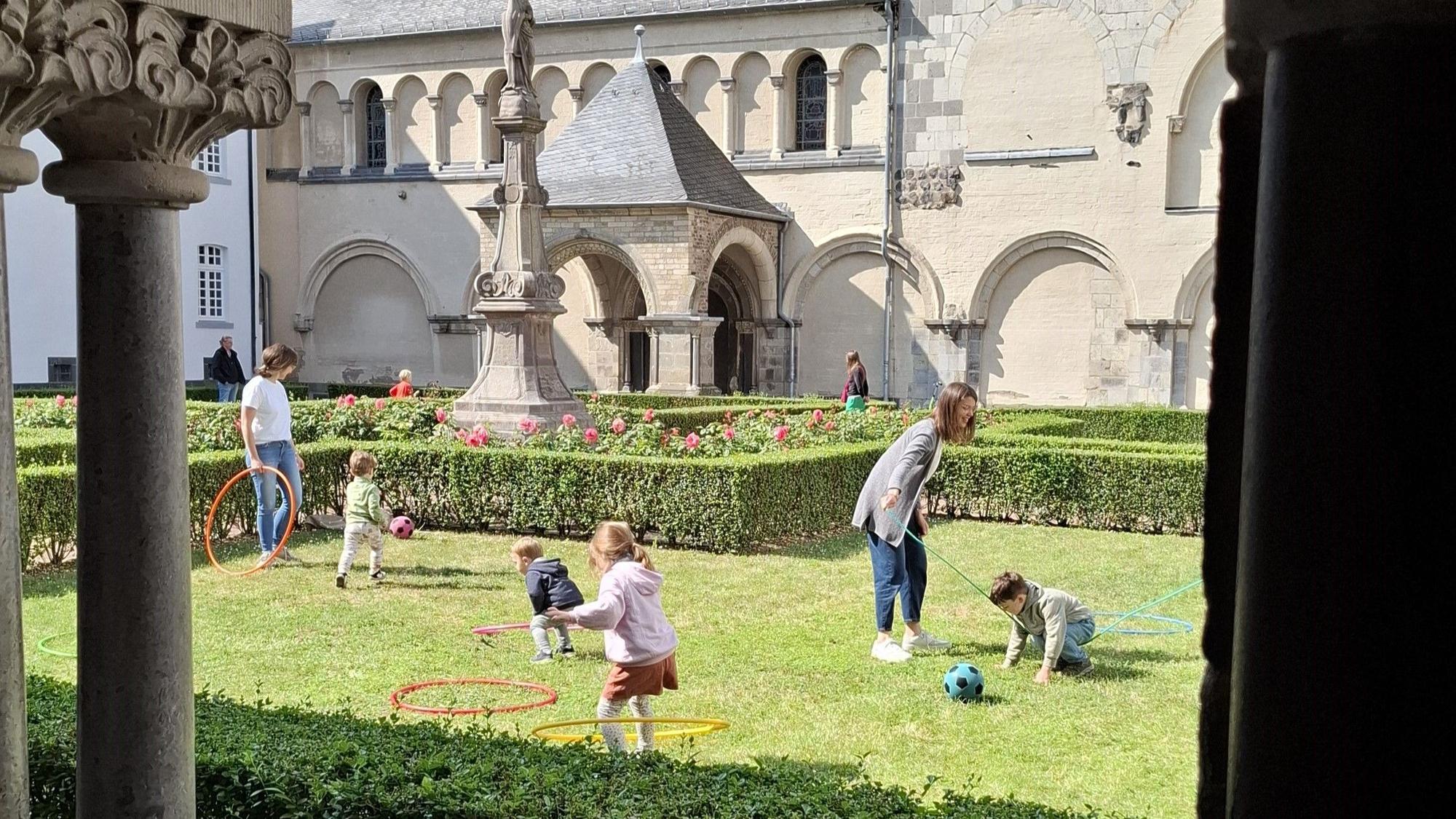 Das Foto zeigt spielende Kinder im Klostergarten der Abtei Brauweiler.