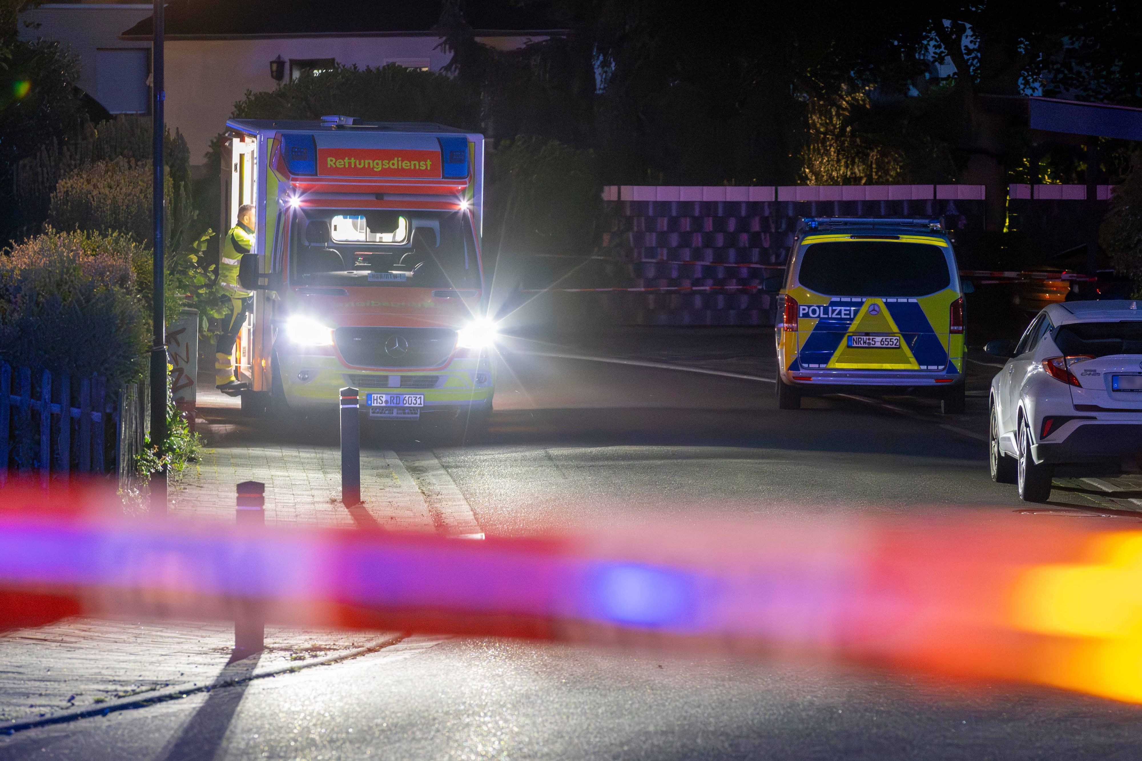 Rettungskräfte und ein Einsatzfahrzeug der Polizei in der Nähe des abgesperrten Tatorts in Wassenberg.