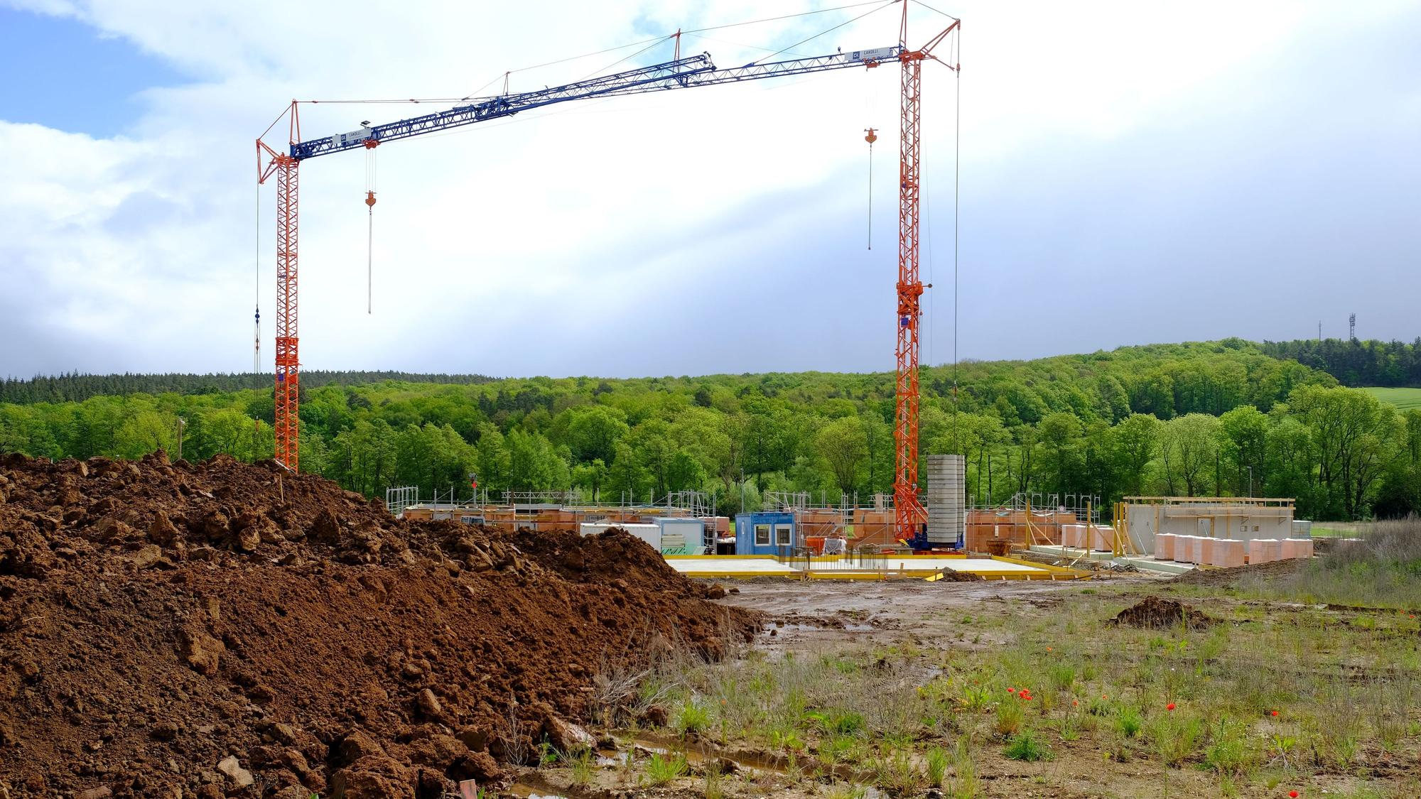 Im Baugebiet Auf der Wäsche in Mechernich sind die Arbeiten für eine umfangreiche Mehrfamilienhausbebauung angelaufen. An einer Baustelle sind zwei Kräne zu sehen.