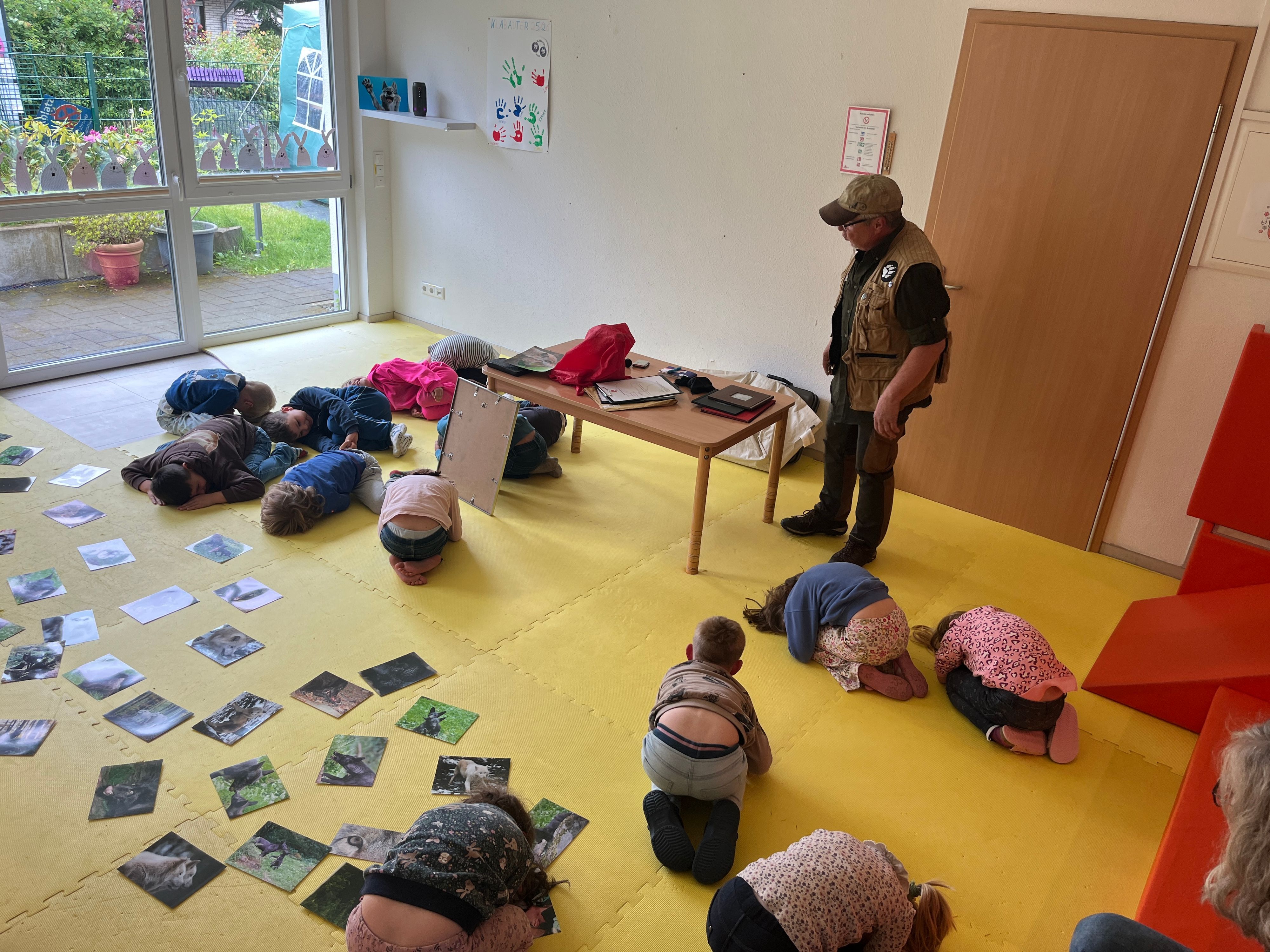 Joseef Schmahl, Wolfskenner aus Hennef, erzählte den Kindern im Aktion-Kindergarten in Neunkirchen-Seelscheid viel über den Wolf, sie selbst mussten das Anpirschen ausprobieren.