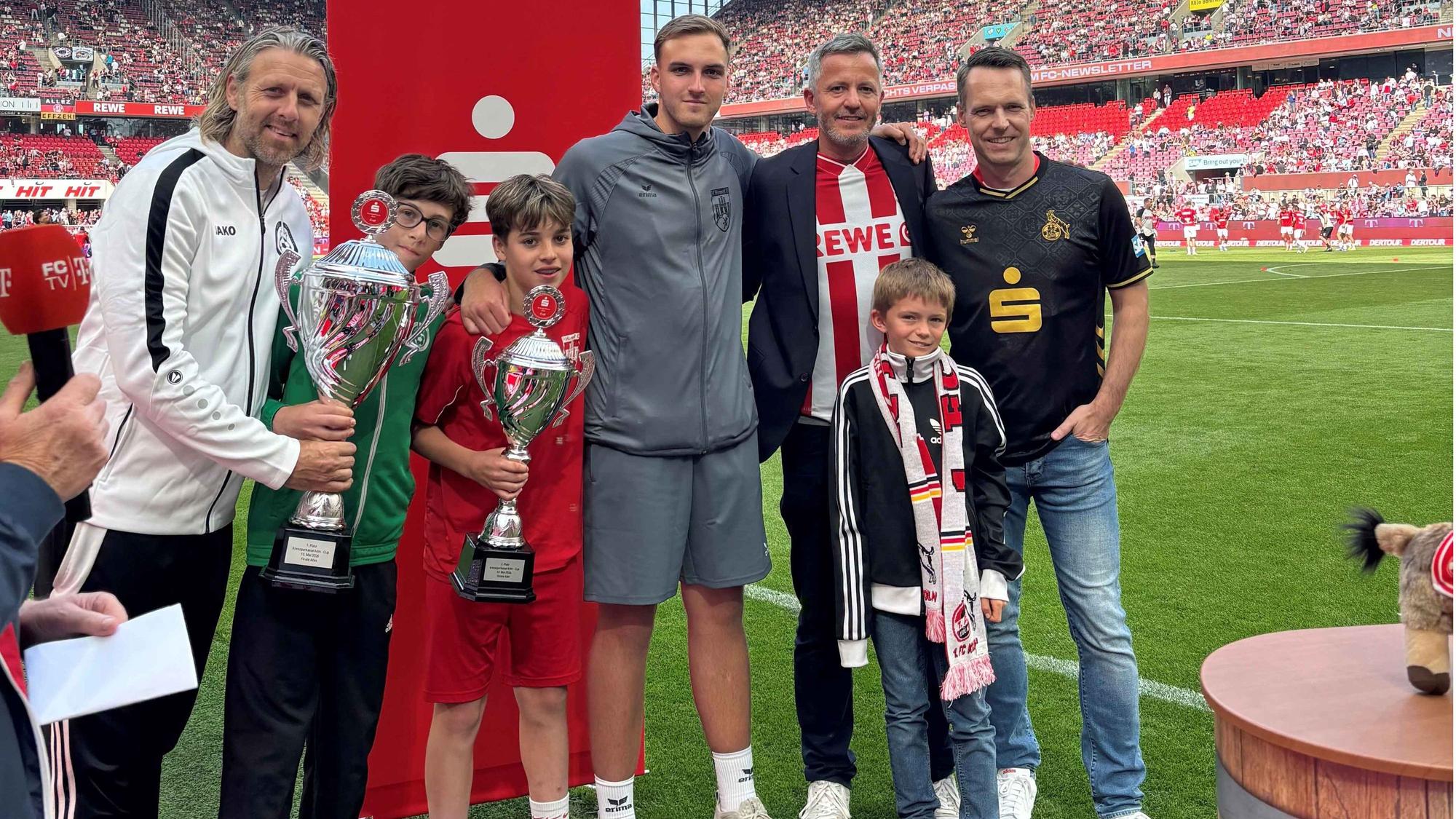 Marco Steinbach, Vorstandsmitglied der Kreissparkasse Köln, und Philipp Liesenfeld, Geschäftsführer des 1. FC Köln (von rechts), überreichten die Pokale an Spielführer und Trainer der beiden Finalisten.