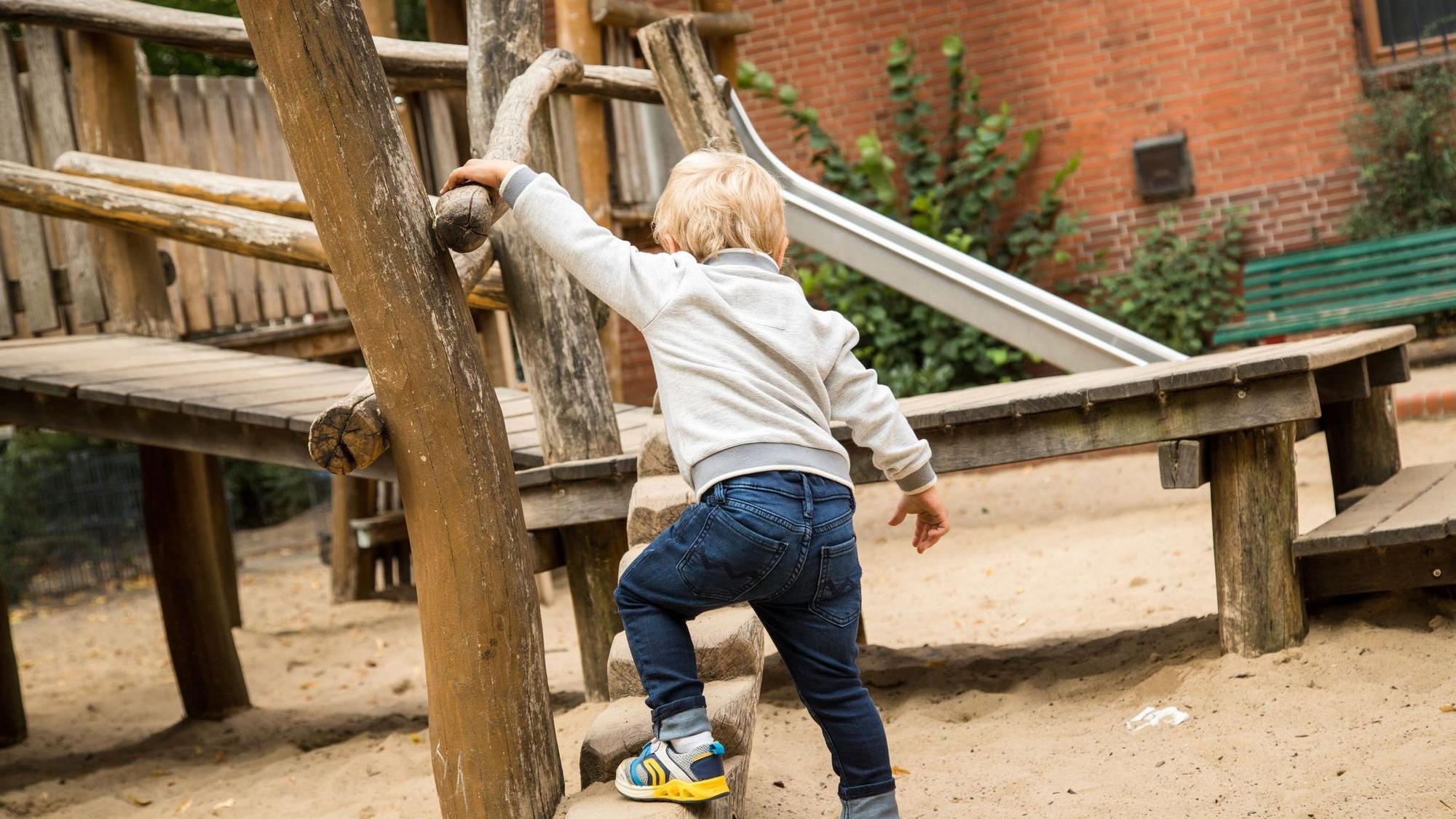 Junge spielt auf einem Spielplatz